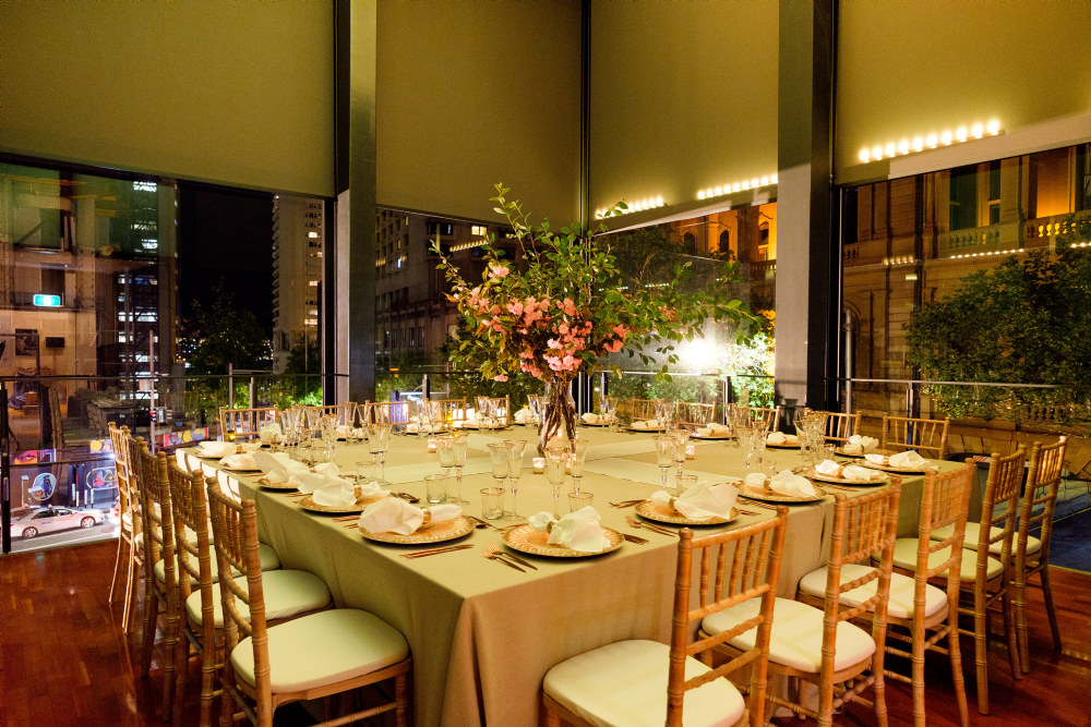 Dinner setting with gold accent lighting in the Viewing Cube at the Museum of Sydney