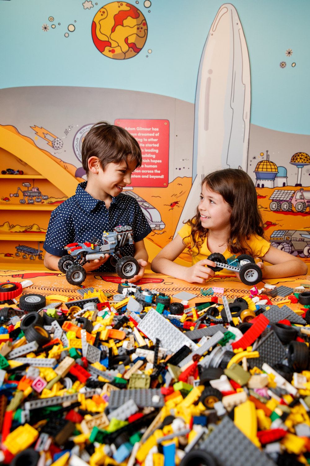 Young visitors building vehicles with LEGO at the On the Move exhibition held at the Museum of Sydney