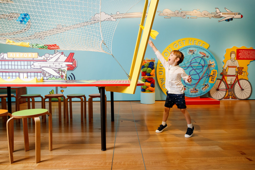 Sebastian Flyte flying a paper airplane at the On the Move exhibition held at the Museum of Sydney