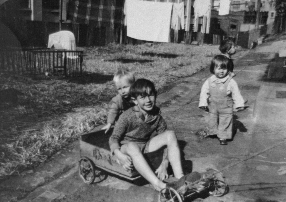  Raymond Smith posing in the billycart his father made, back lane (Cambridge Street)