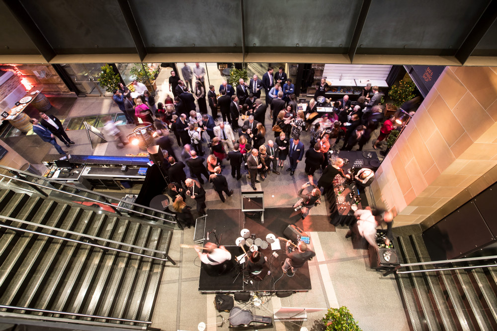 Guests attending a cocktail party in the foyer of the Museum of Sydney