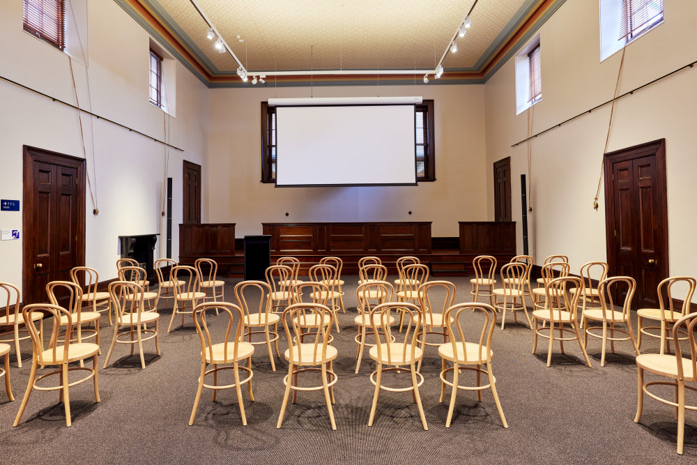 The Water Police Court at the Justice & Police Museum with a theatre seating setup and large projector screen for venue hire.