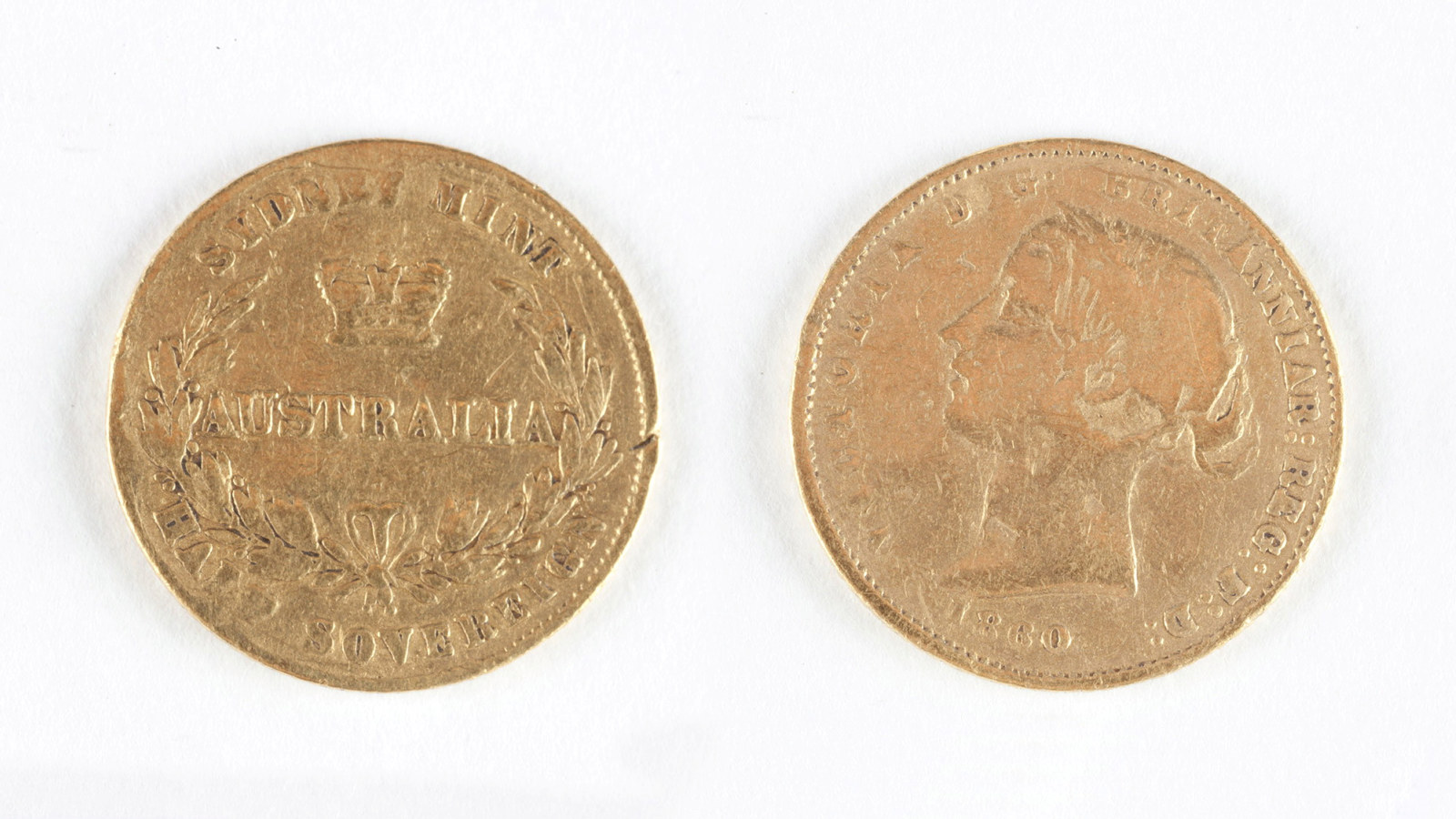 Front and back of gold coin, showing details of inscription. Embossed text obverse side of coin; â€˜VICTORIA D:G: BRITANNIAR: REGINA F:D: 1860â€™. Embossed text reverse of coin; 'SYDNEY MINT / AUSTRALIA / HALF SOVEREIGN'.