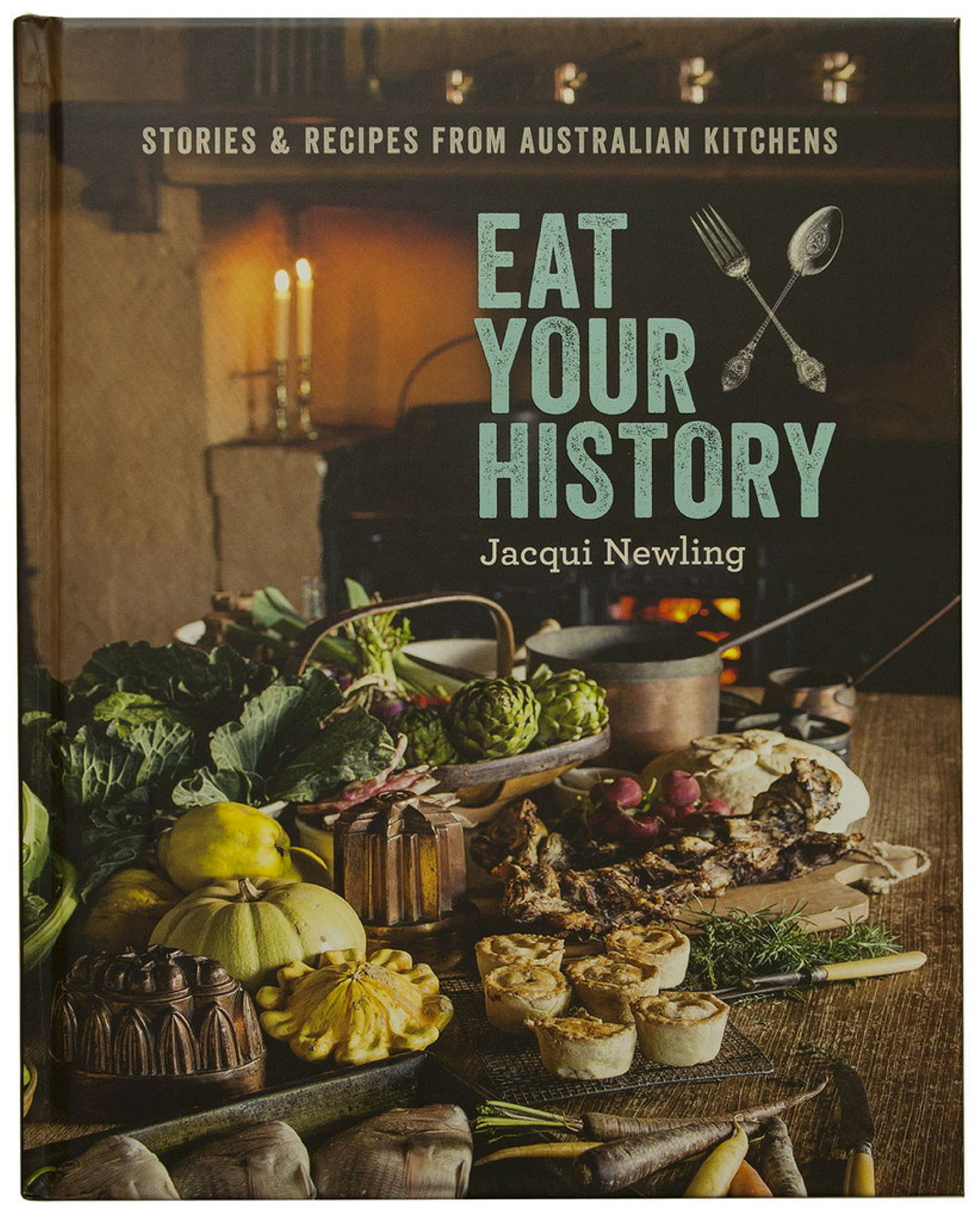 Cover of Eat your history cook book. Picture of food on a table with fire in the background.