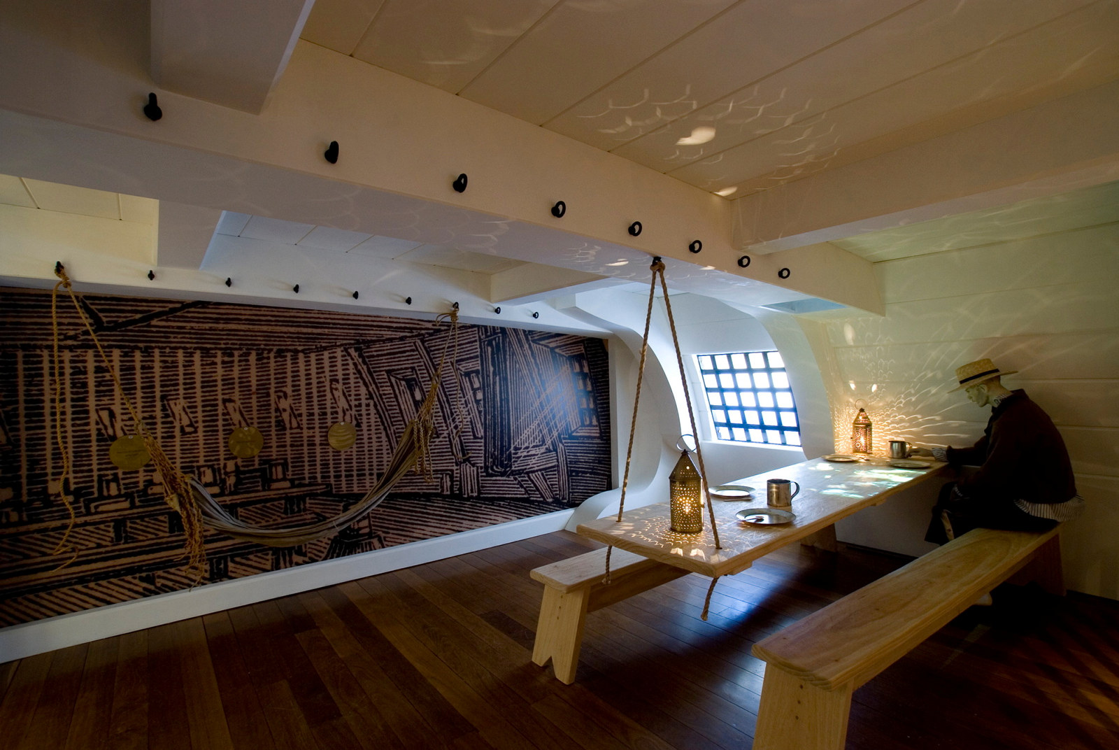 Exhibition installation; hulk cabin with wooden panelling, beams, convict figure