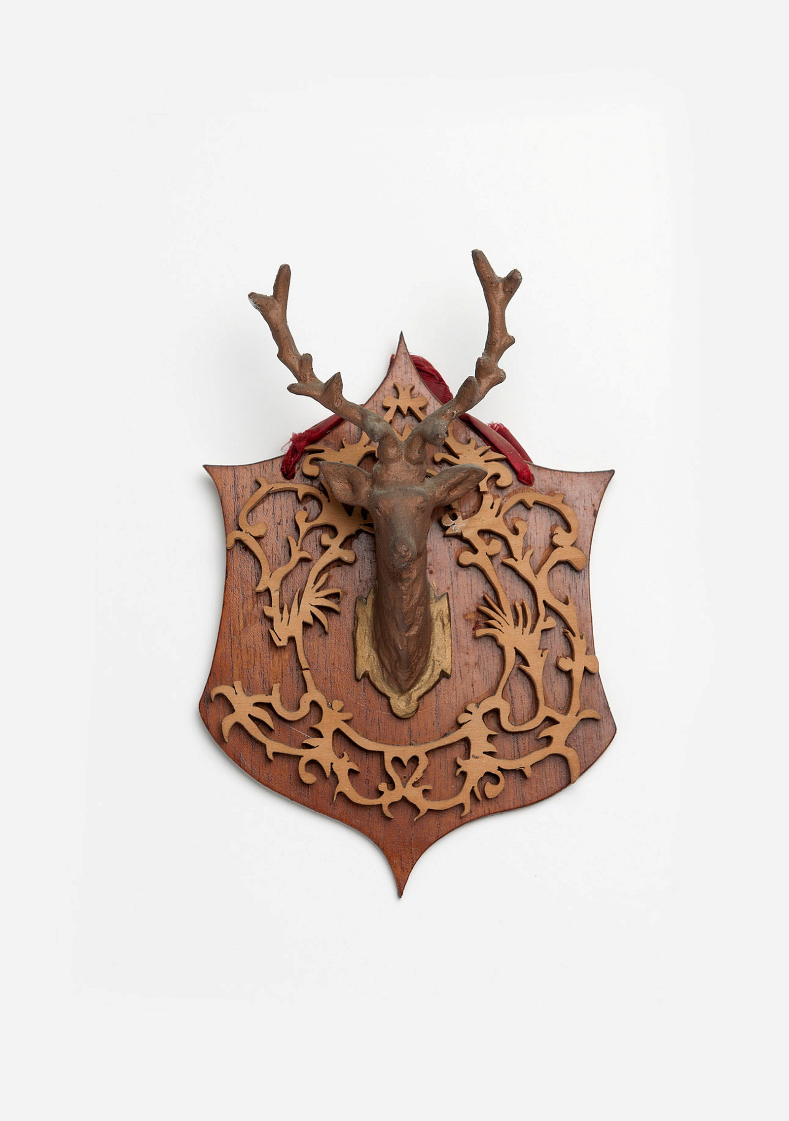 Stag's head mounted on crest-shaped backing.