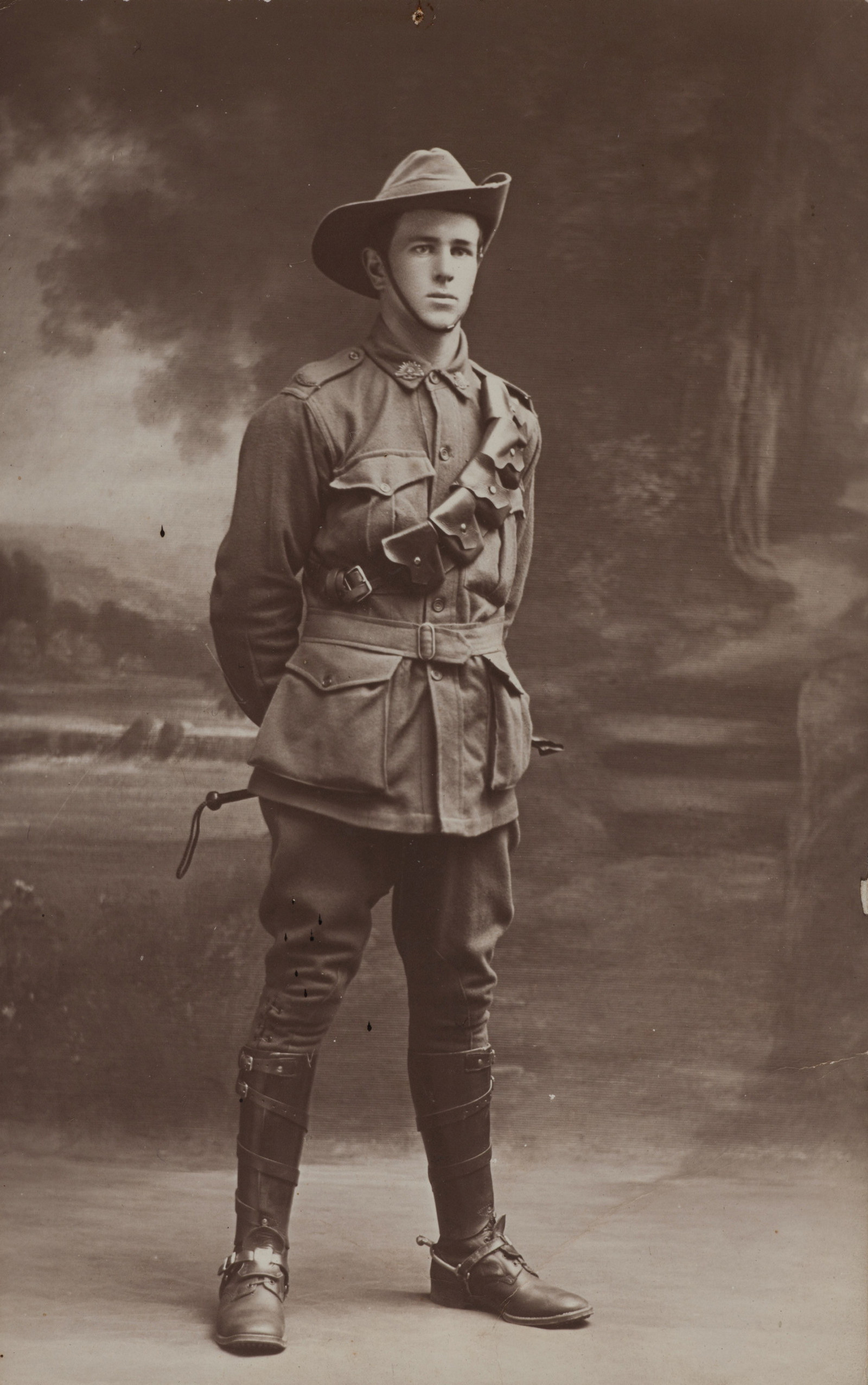 Black and white full length portrait of young man in uniform.