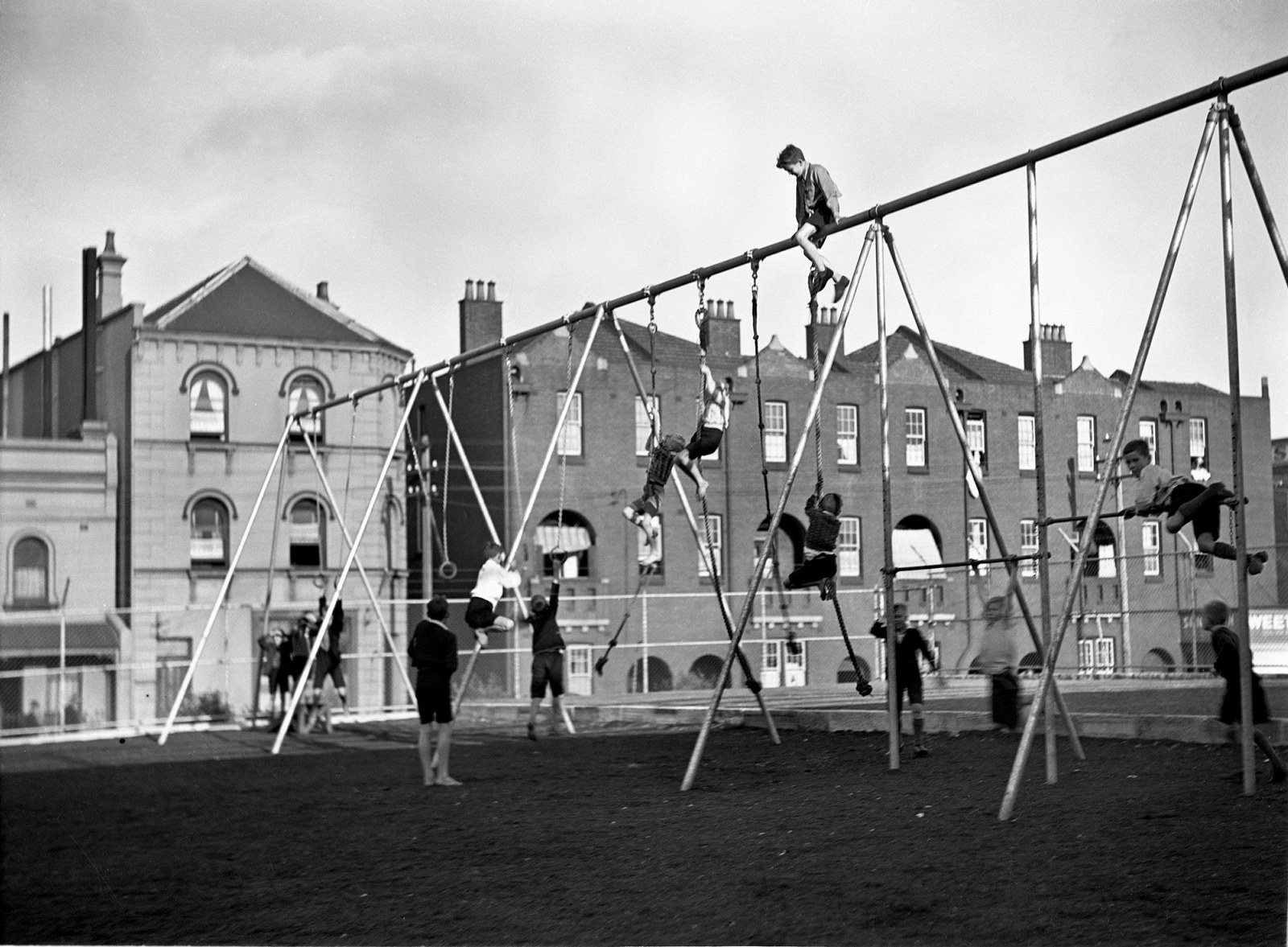 Black and white photo of children playing on equipment.