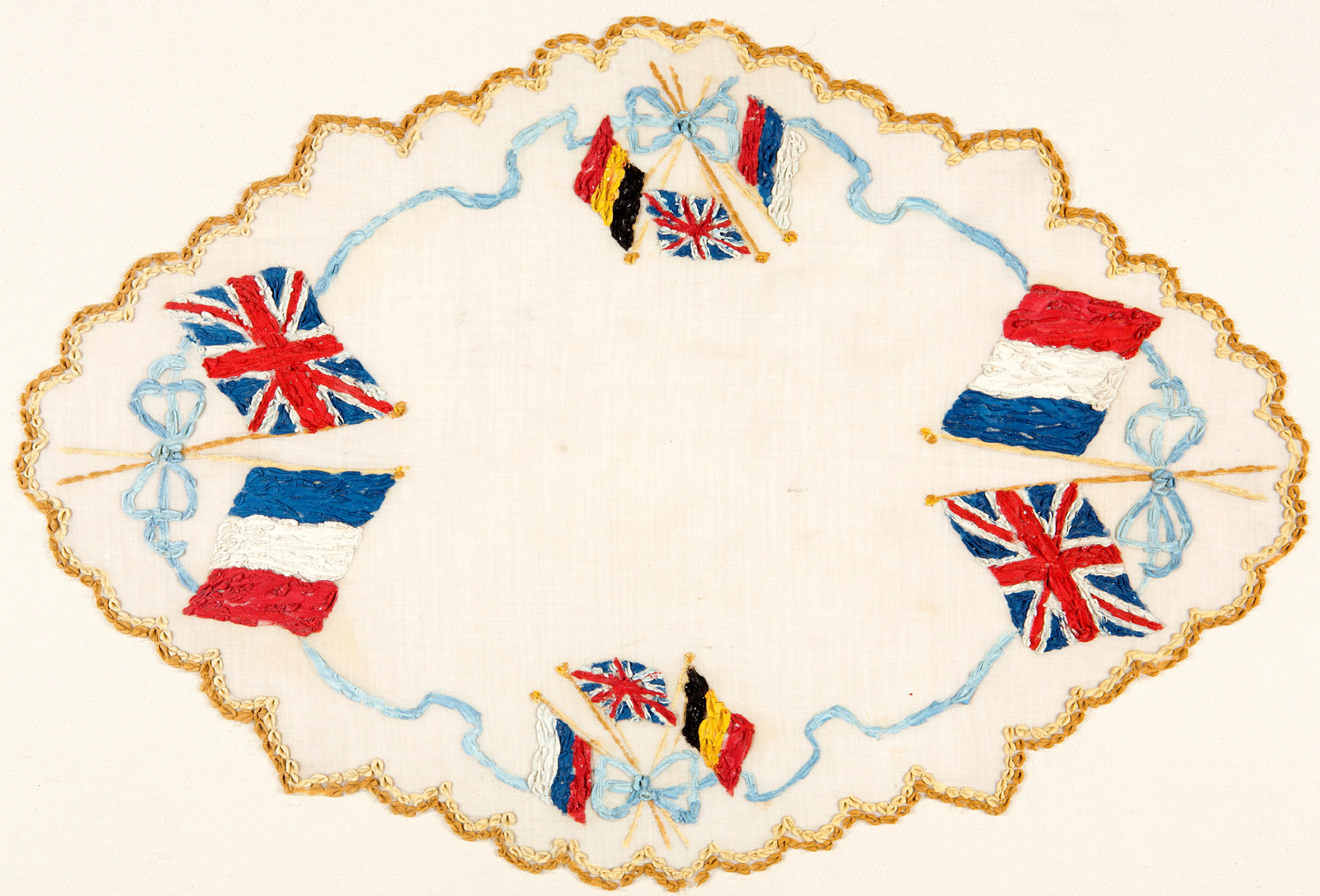 Cream doily with scalloped edge and hand painted with flag designs.