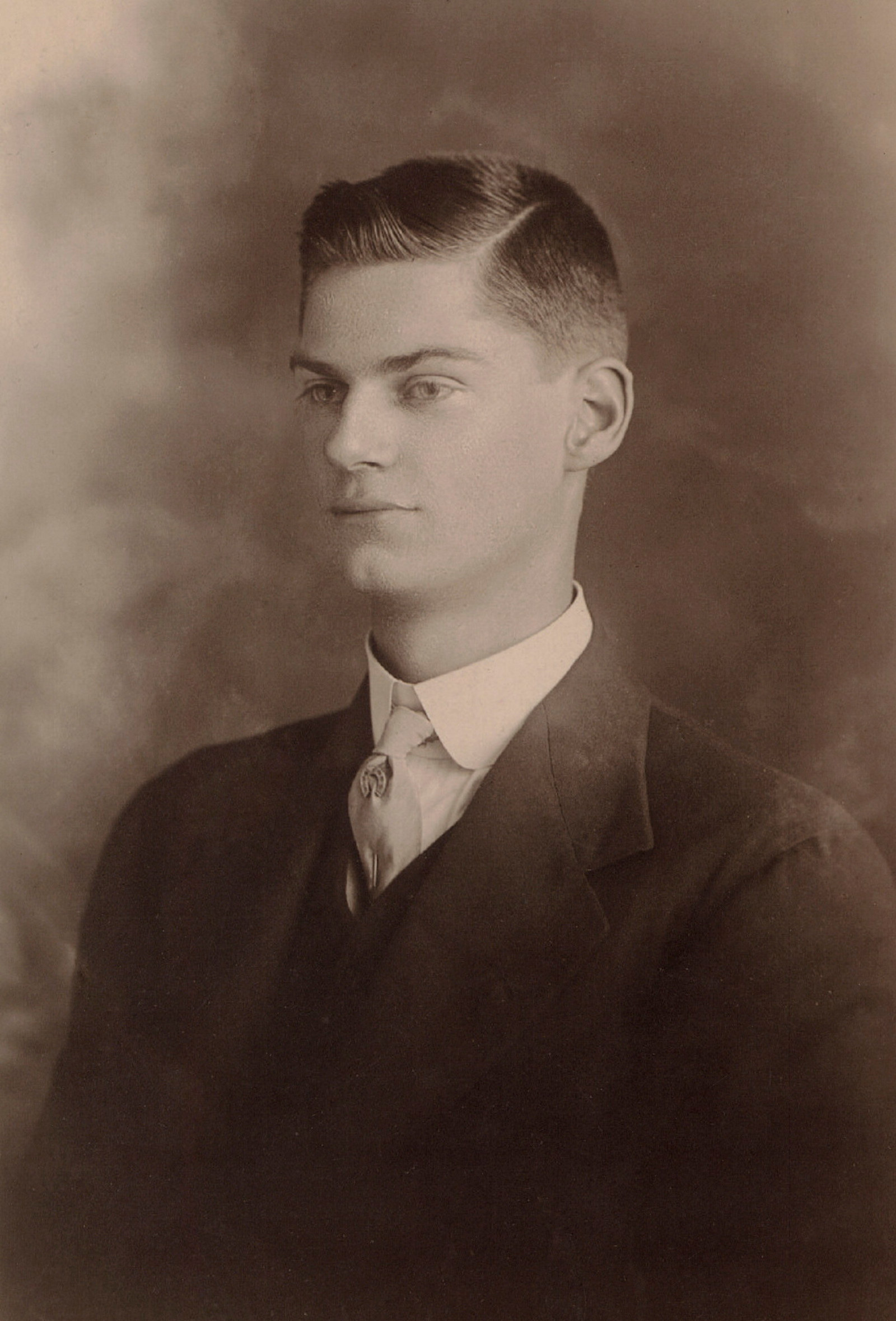 Black and white portrait photo of young man in suit.