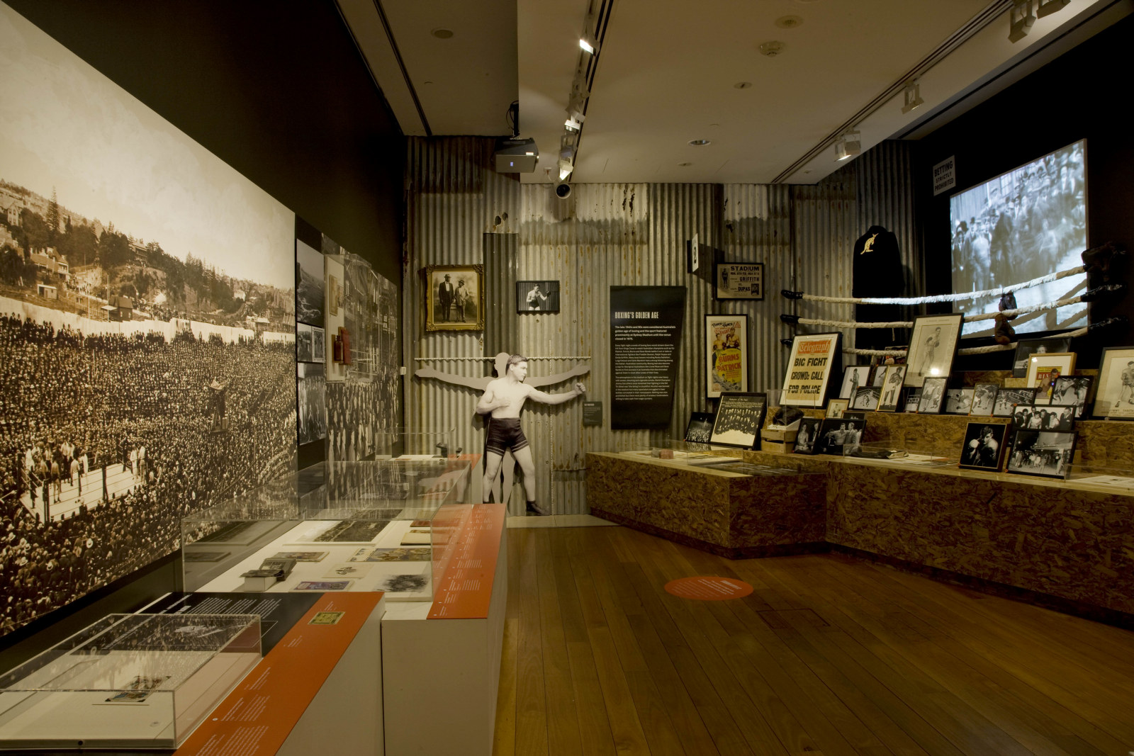 Exhibition interior showing display cases and pictures on the walls.
