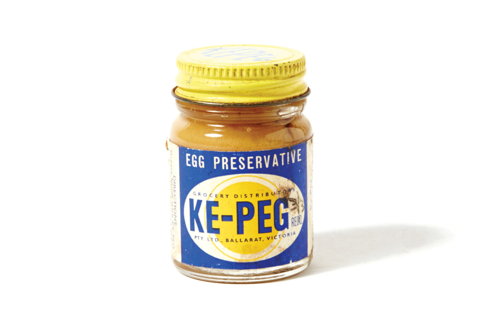 Jar with yellow lid and blue label with the word KE-PEG on a yellow and white stylised egg.