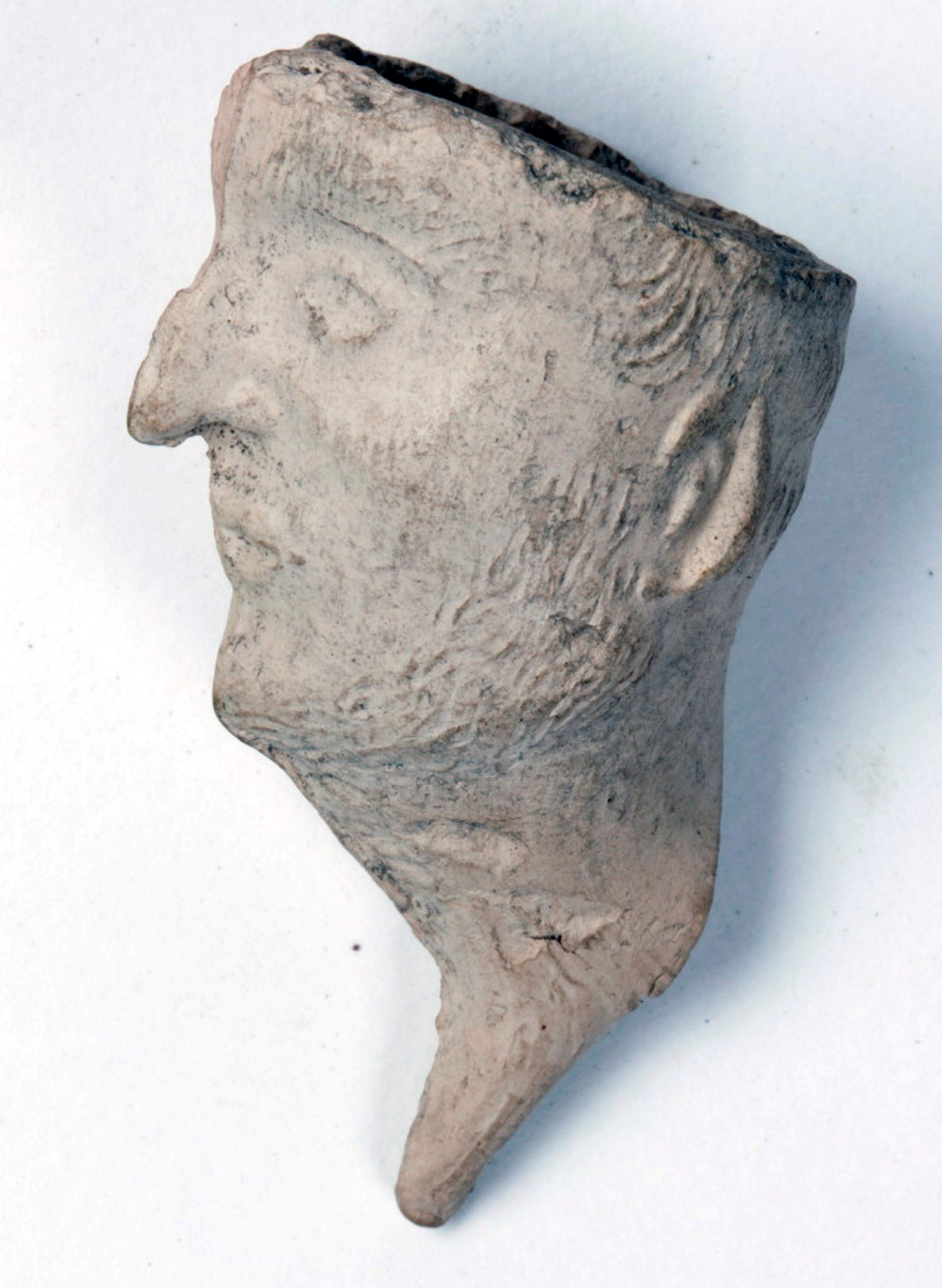 Profile view of clay pipe carved into man's head with beak-shaped nose.