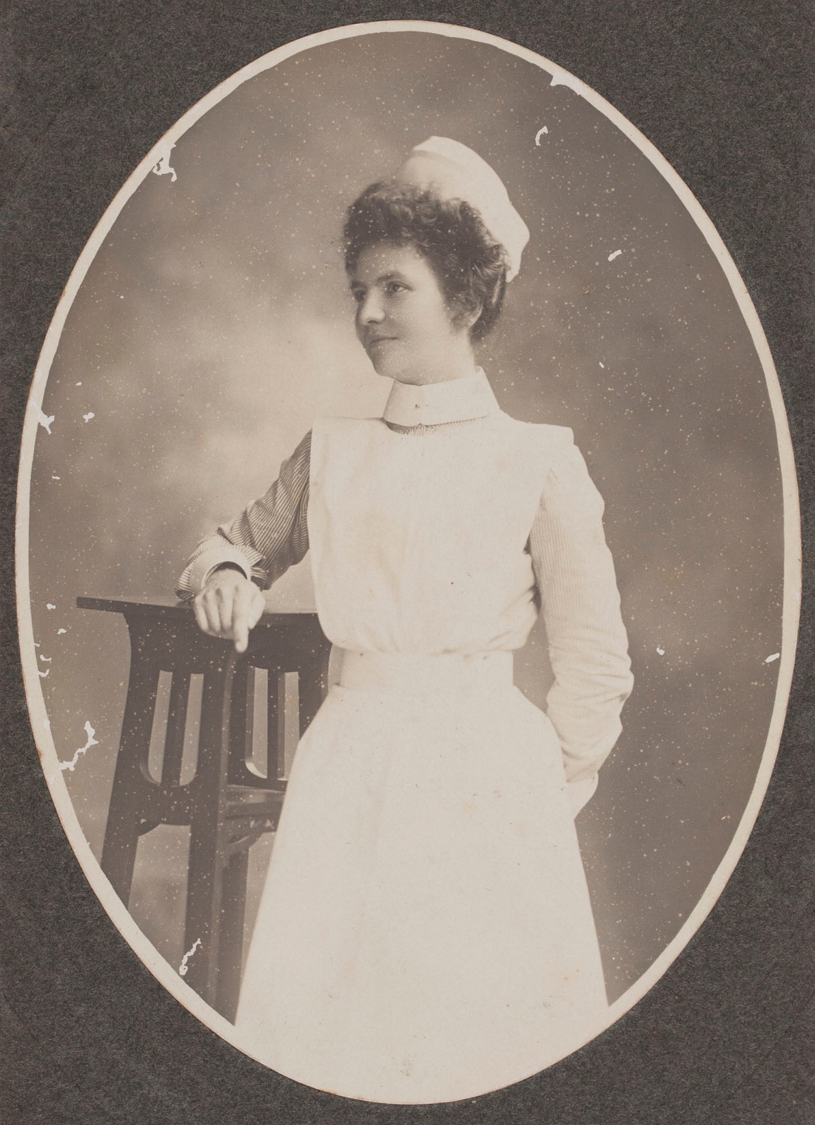 Cameo of woman in white uniform and cap.