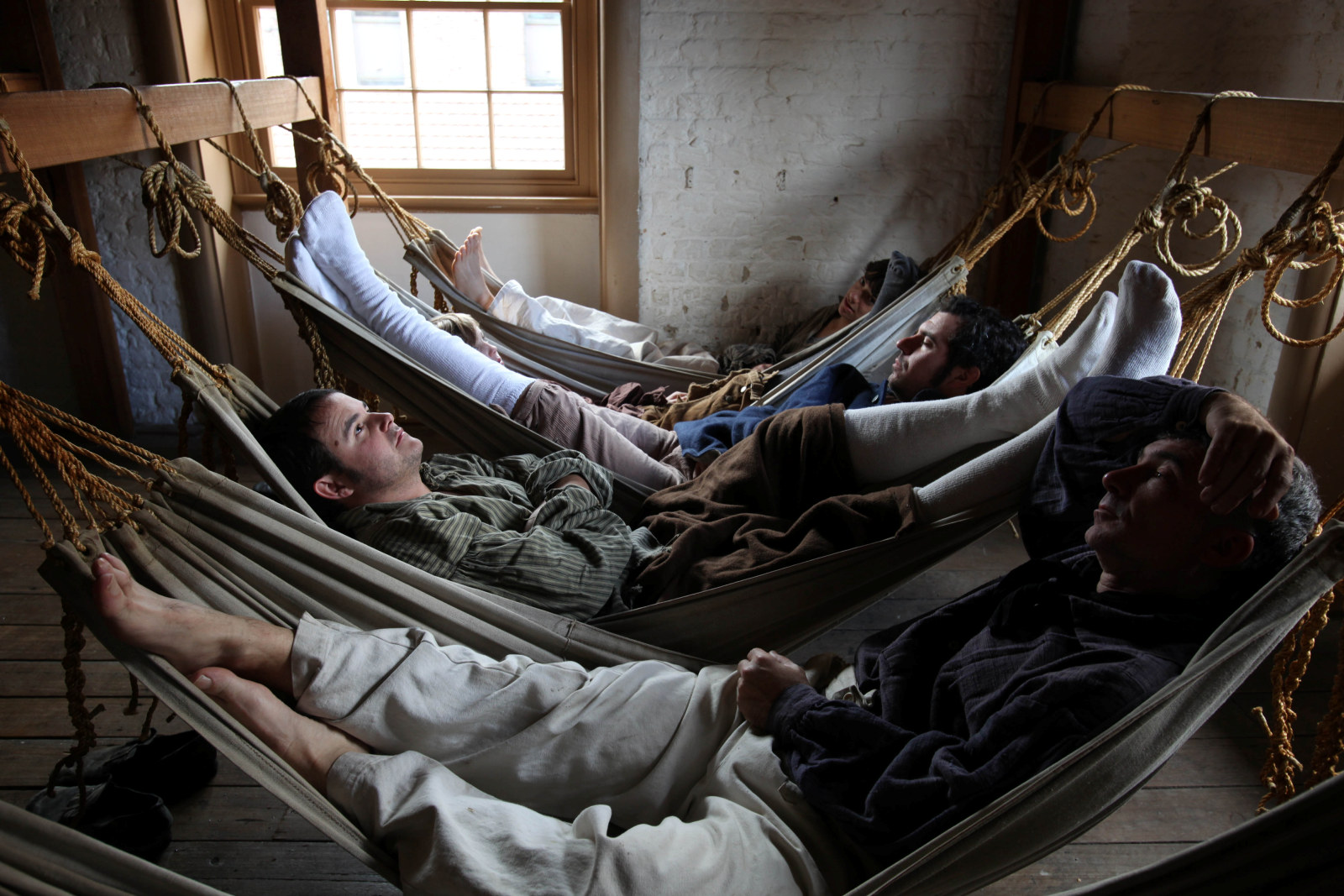 Reenactment of 5 convicts lying in hammocks