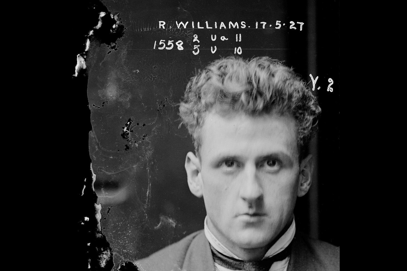 Black and white photo of man's face with white writing on negative visible to one side.
