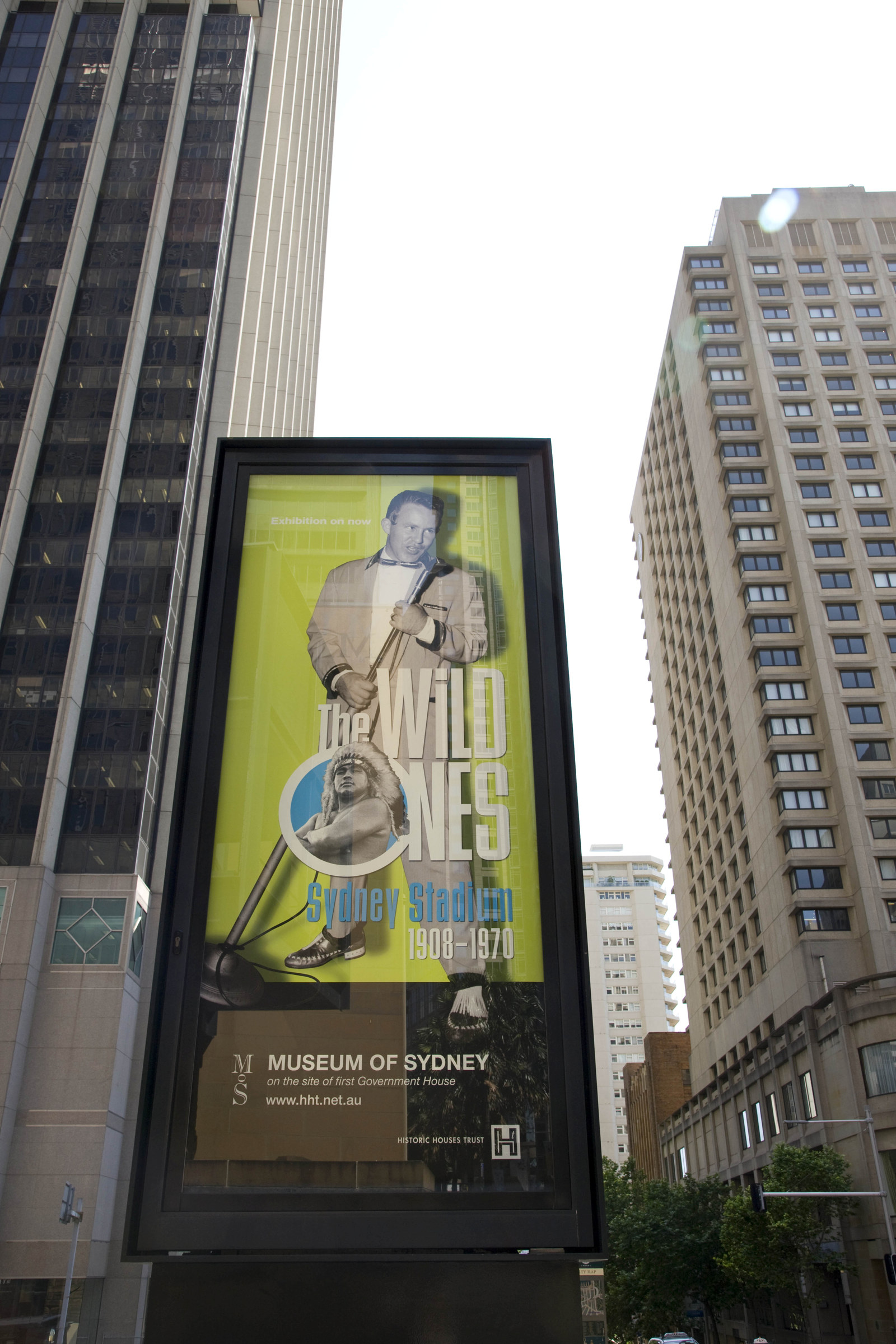 Large sign outside museum reads Wild Ones with a picture of a man holding a microphone.