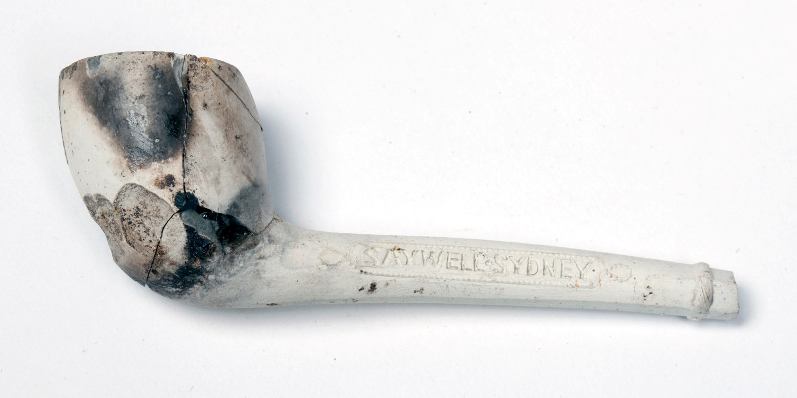 White clay pipe and stem with lettering.