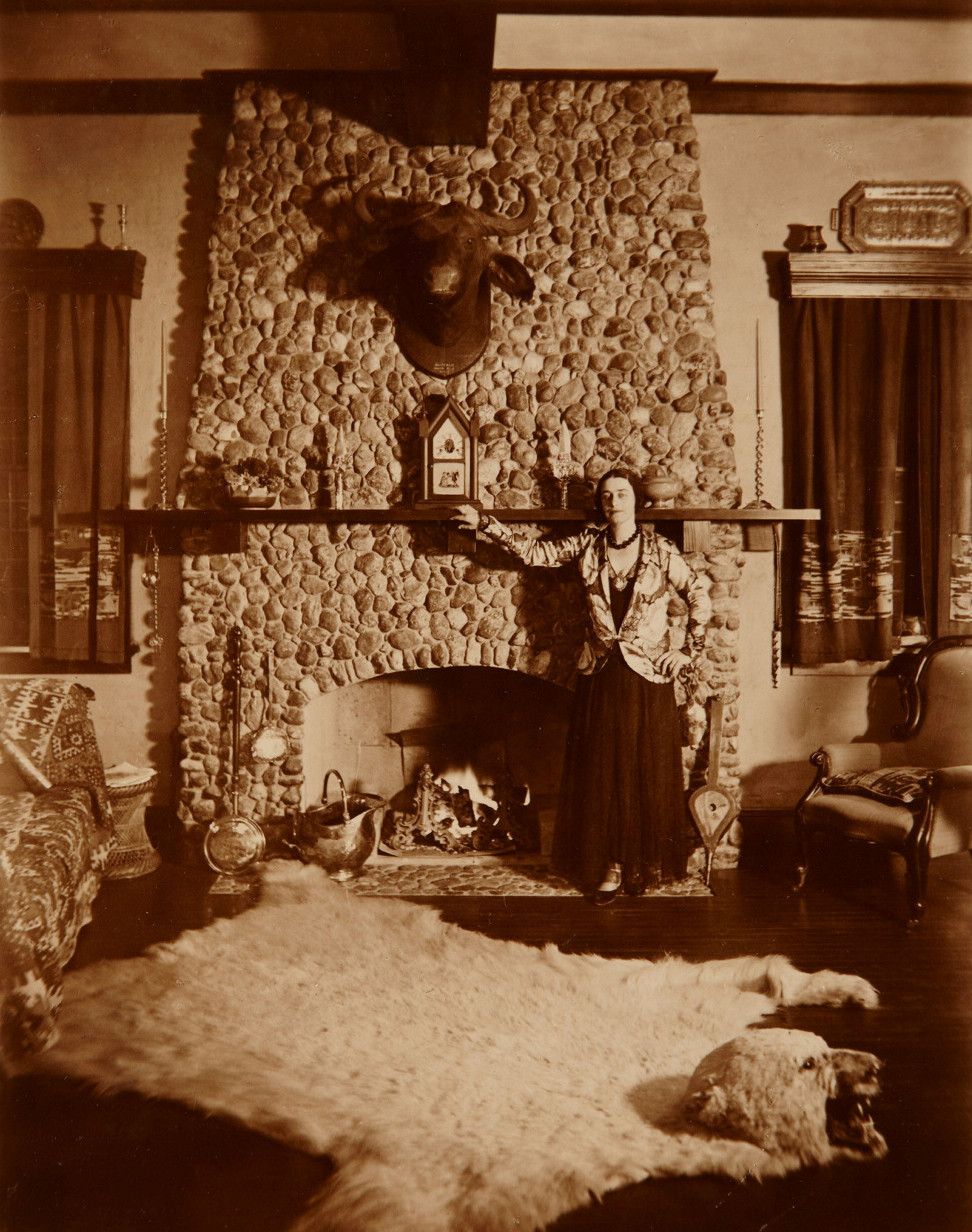 Mrs Muriel Mackay standing by the fireplace in the living room of Tinagroo homestead near Scone New South Wales, c1925