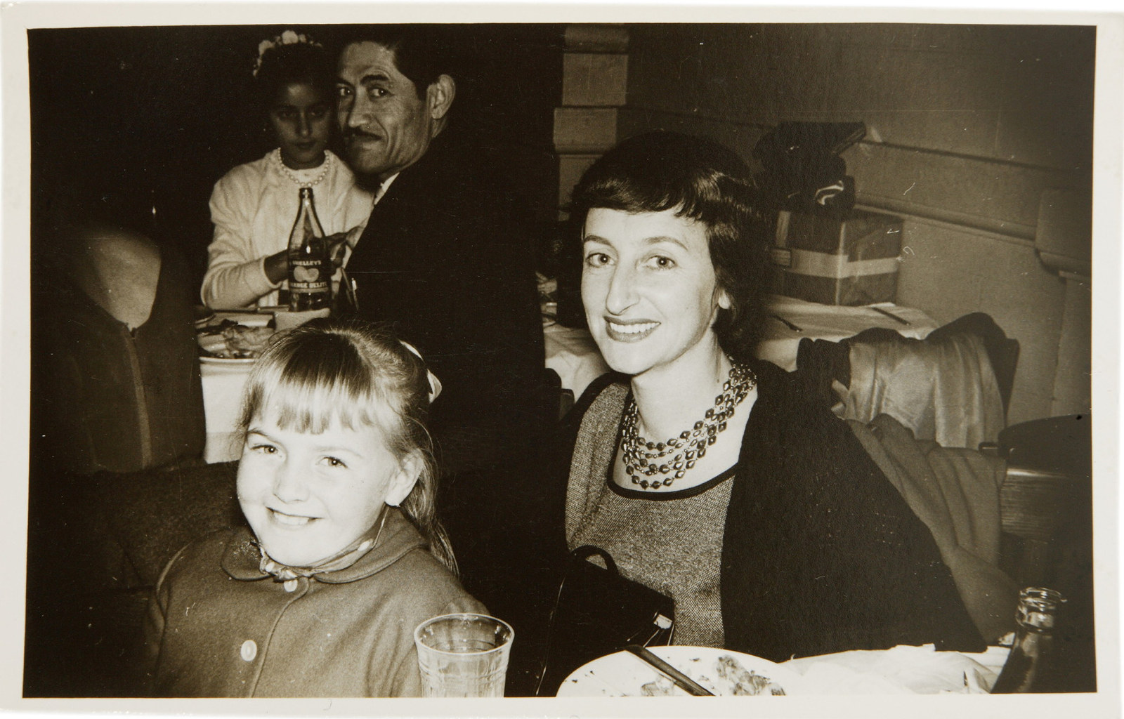 Black and white photo of woman and child in restaurant setting.