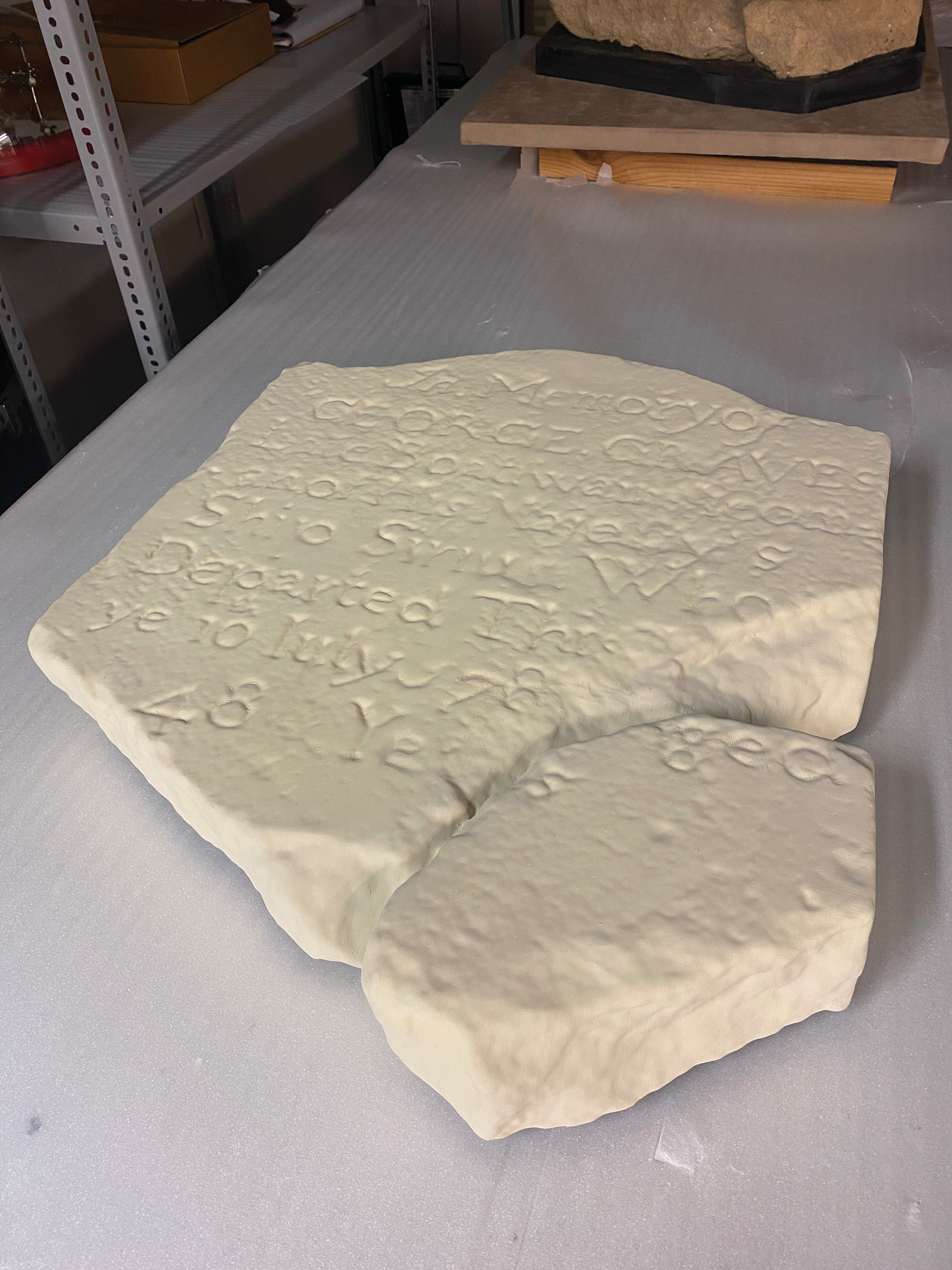 3D print of sandstone headstone lying flat on a metal table