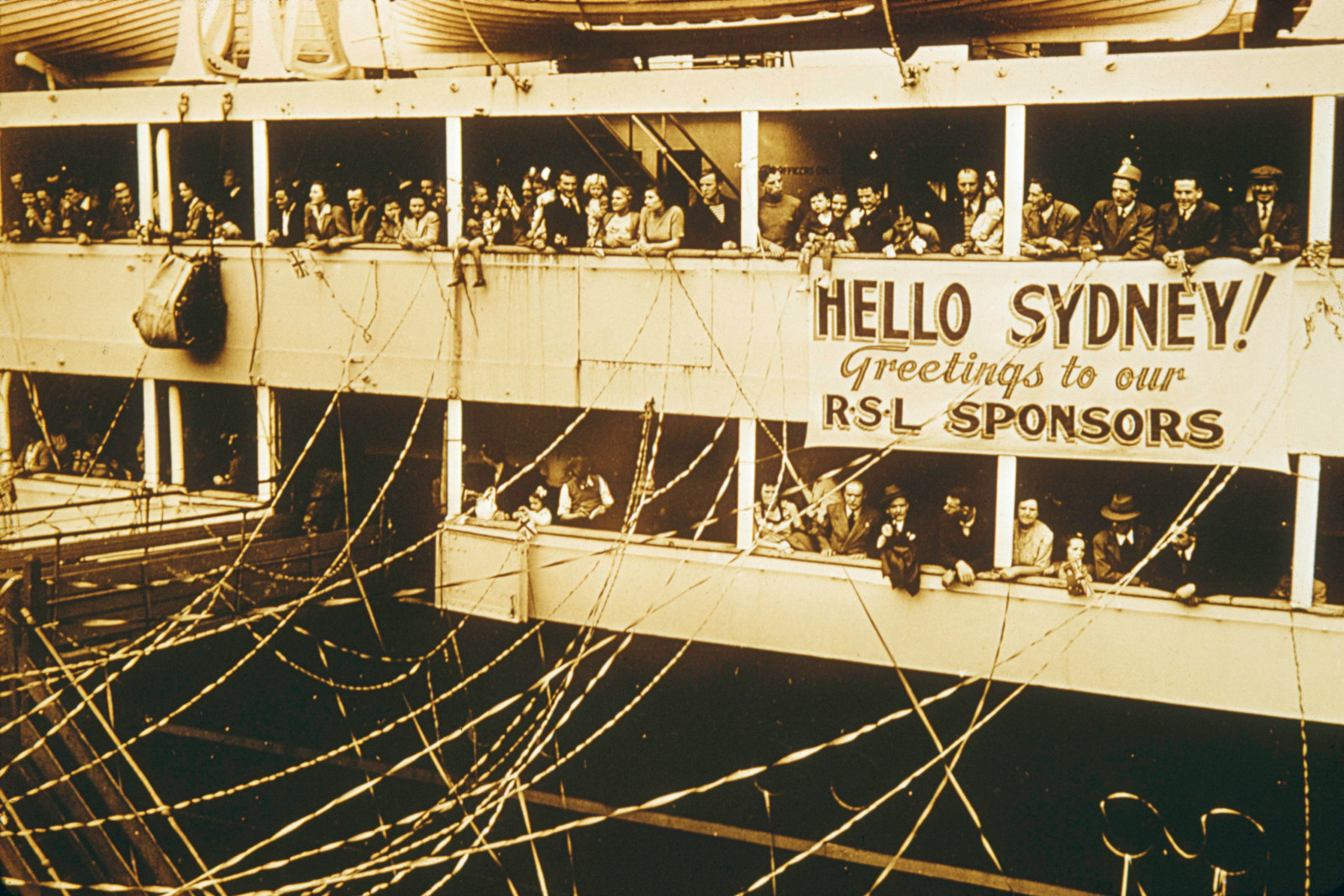 Sepia photograph of people waving from a ship.