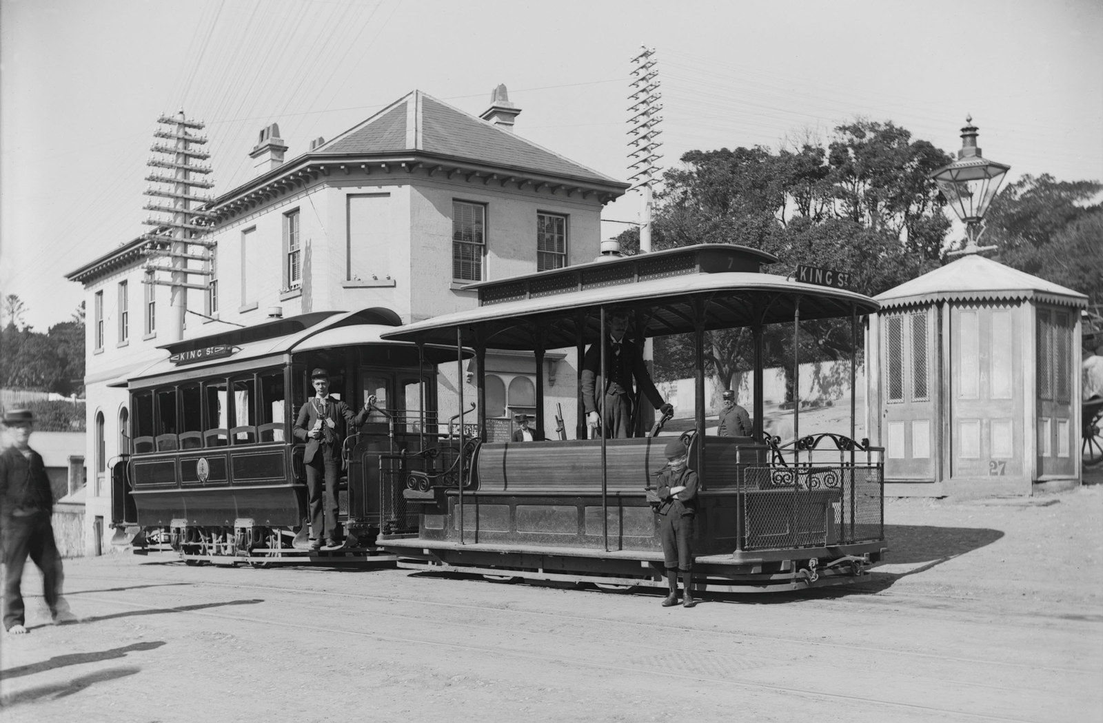 double carriage cable tram on the strret outside a Victorian building.