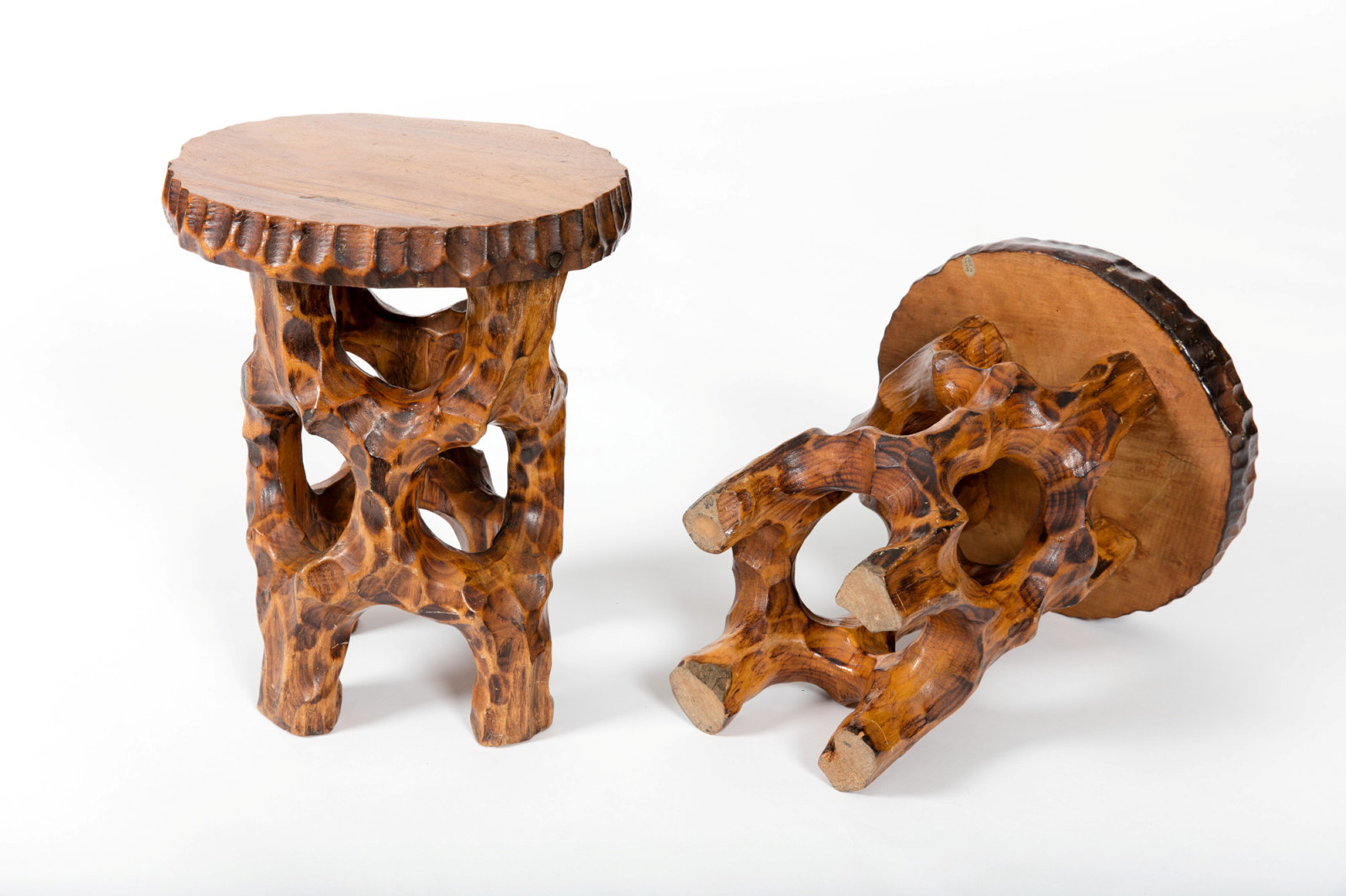 Pair of carved round topped tables with rustic timber legs.