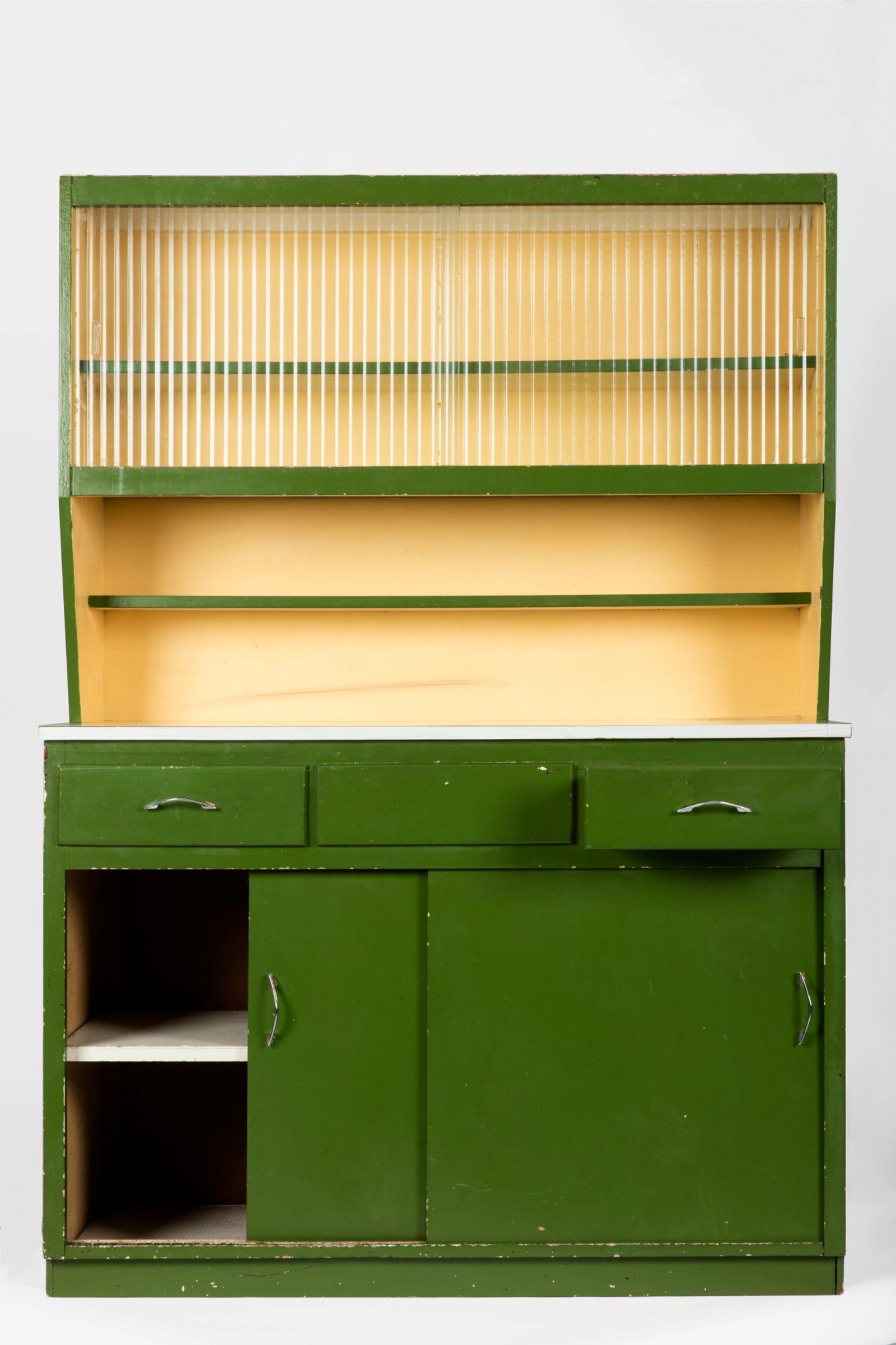 Green drawers with cream shelving above.