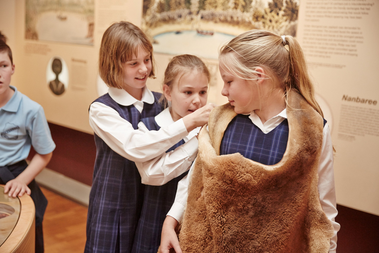 Three girls trying on a skin in exhibition space.