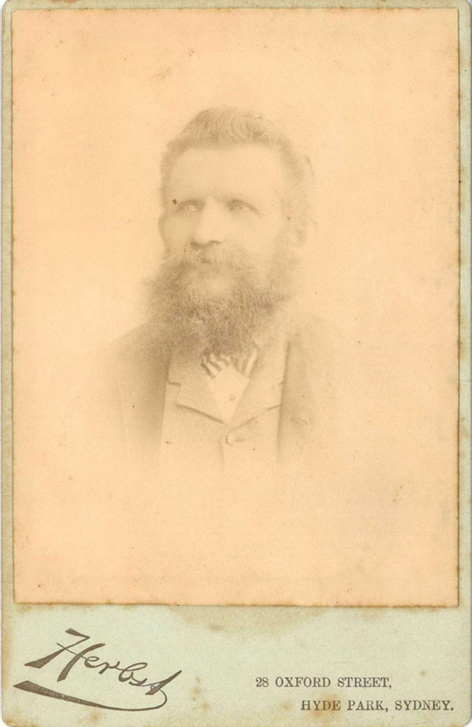 Faint photograph of bearded man.
