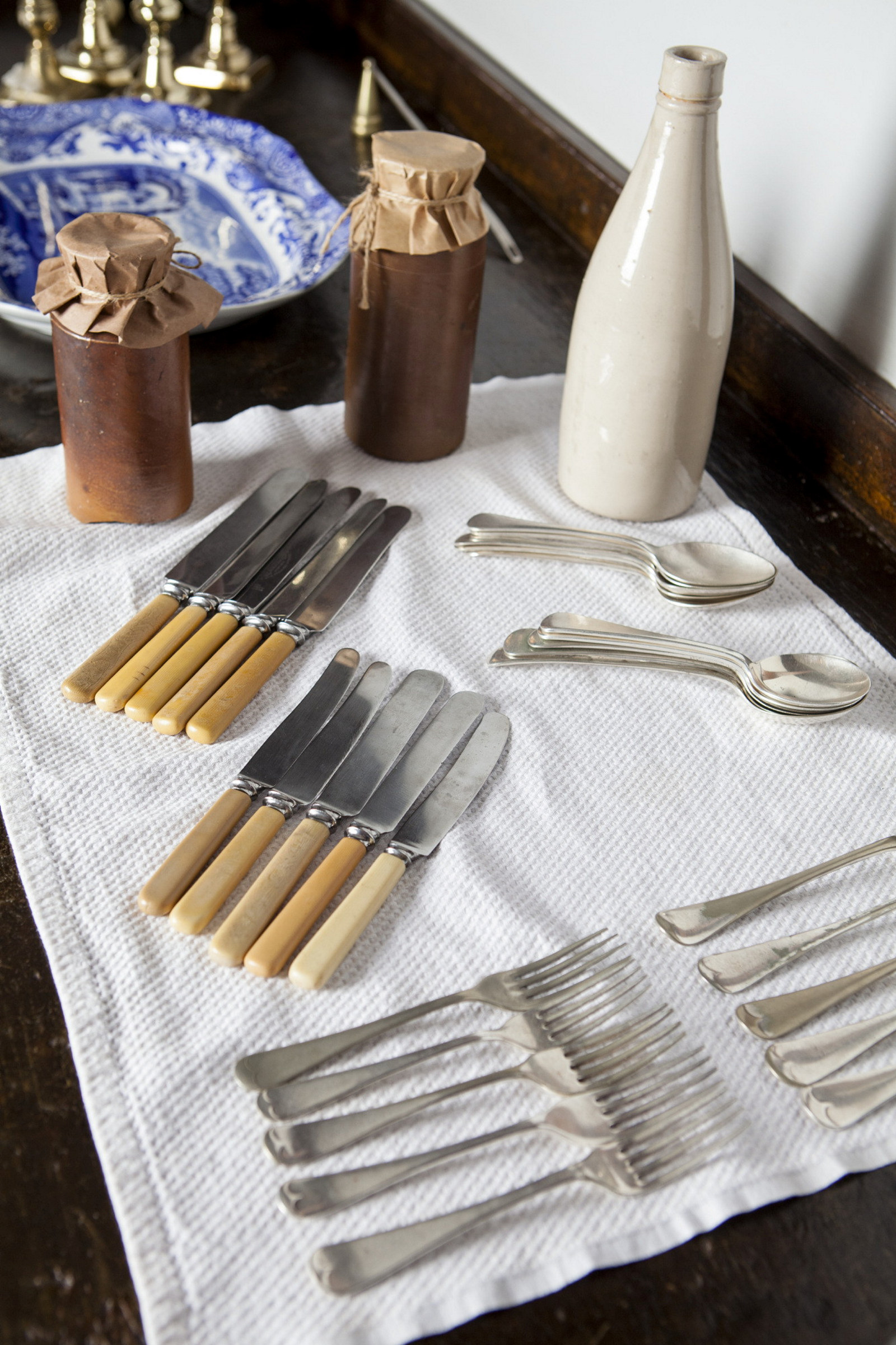 Cutlery and condiments laid out on cloth.