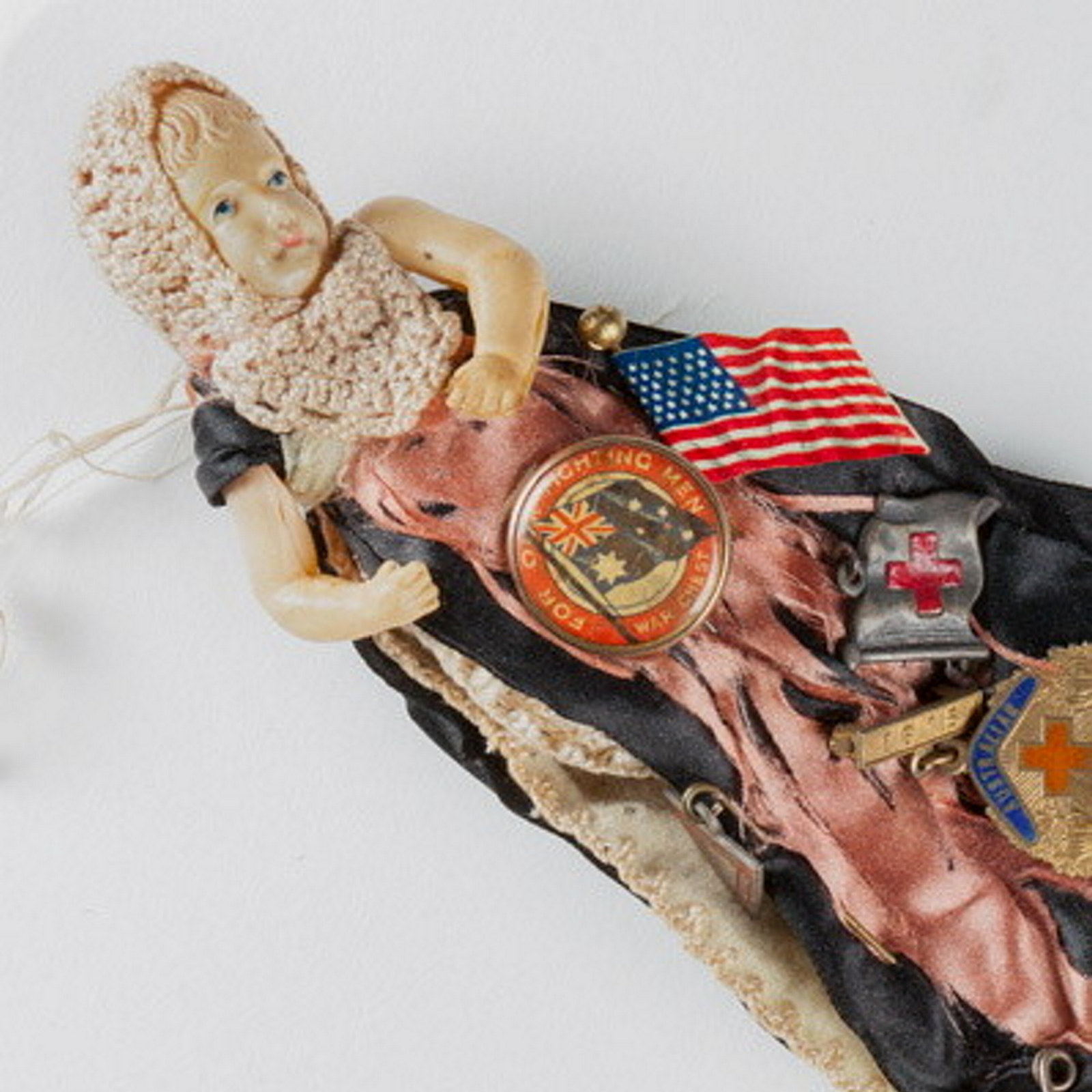 Closeup of doll dressed in badges.