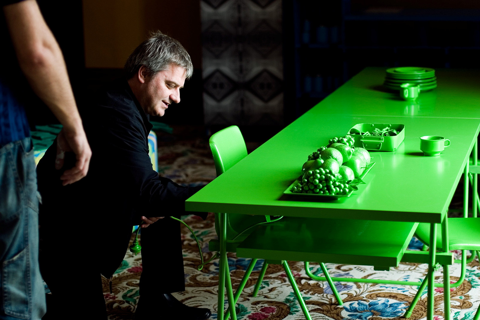 Image of a man making adjustments to a green table