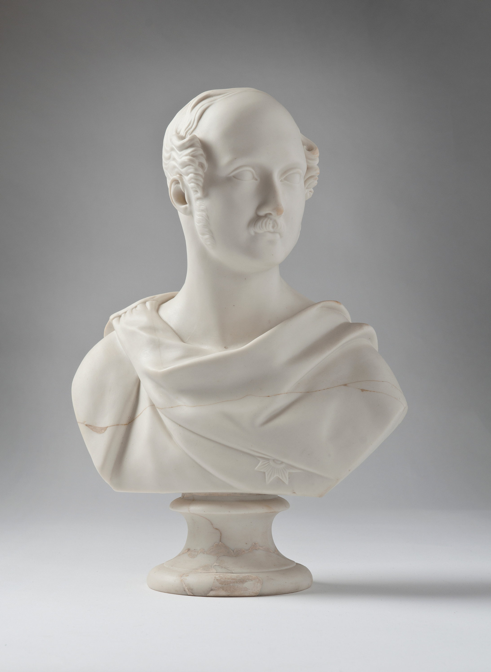 High 3/4 profile bust of man with moustache and sideburns, robed.