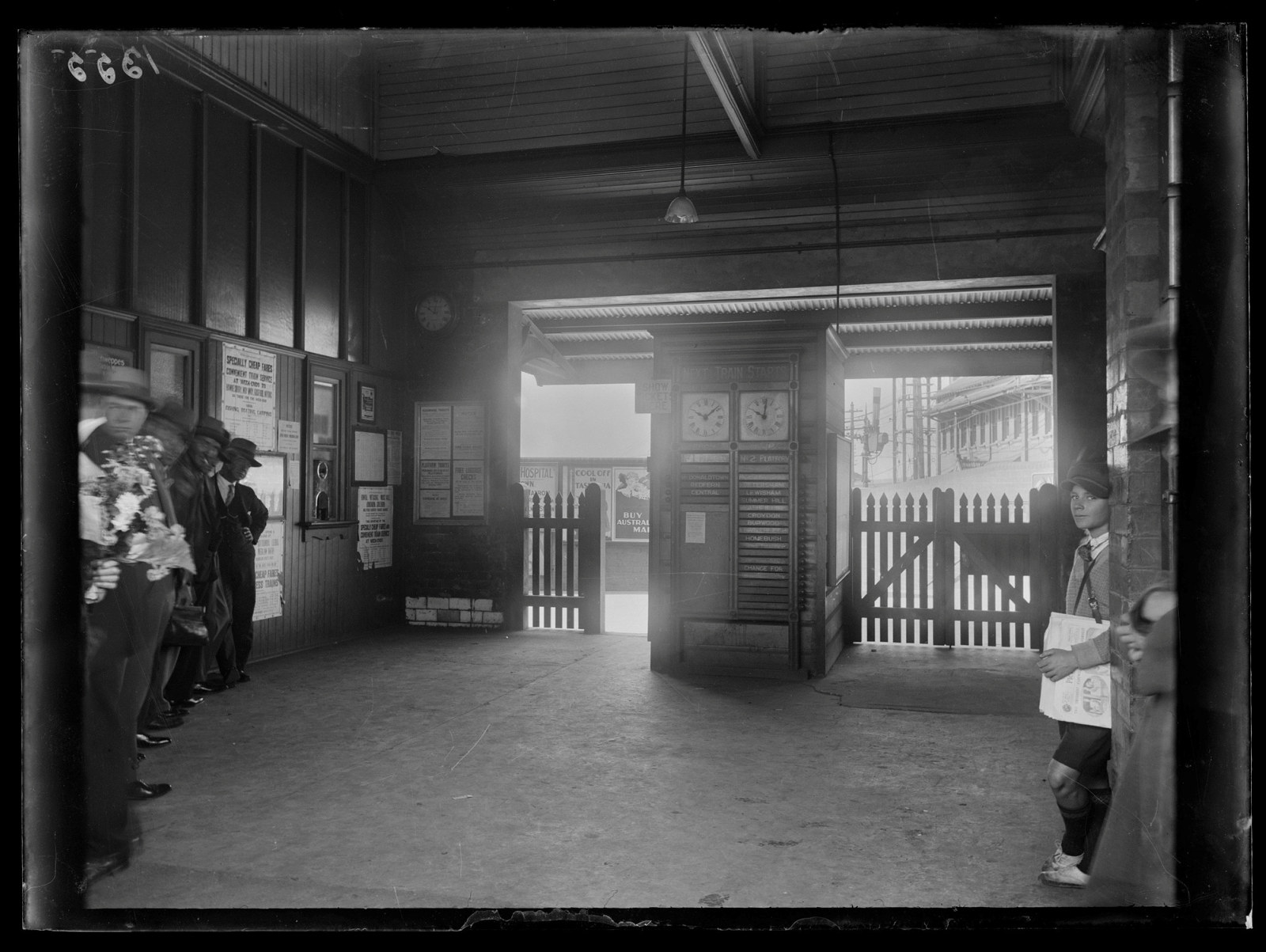 Black and white photo of interior of station entrance way, looking out to street.