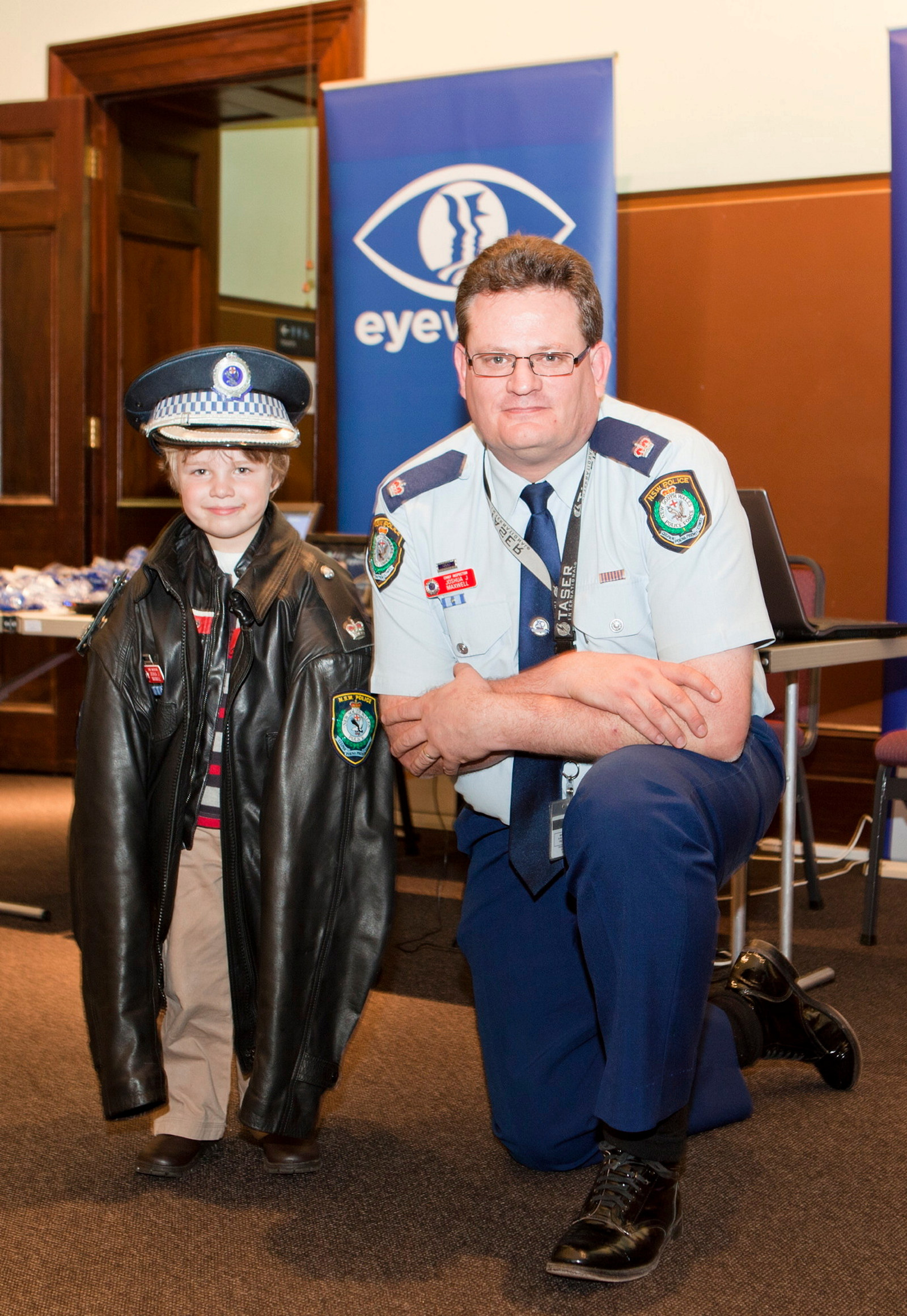 Josh Maxwell, from NSW Police Eyewatch, lends his uniform coat and hat to Stephen for a photograph in the Water Police Court at the Justice and Police Museum