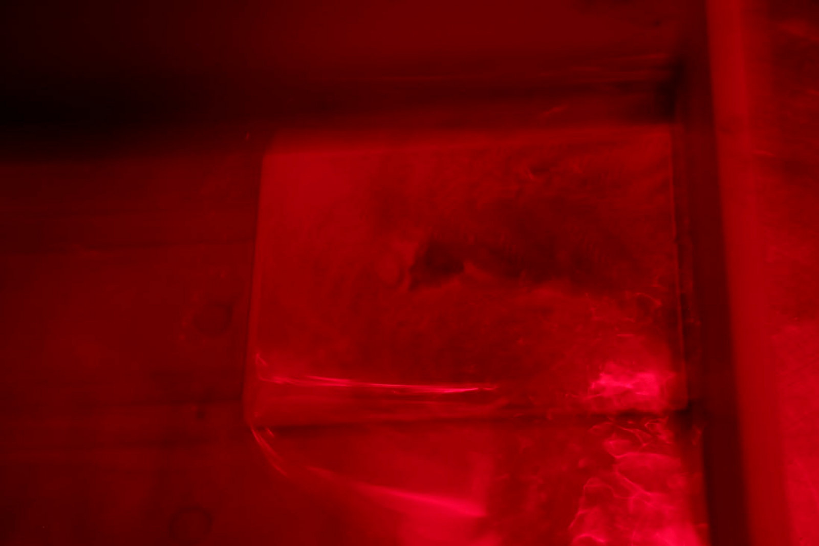 Red light illuminating plate in liquid.