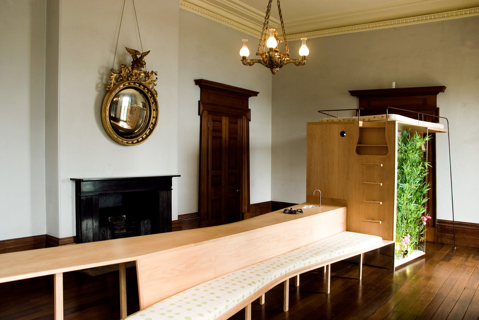 Long timber structure kitchen and seating structure in an ornate Georgian room