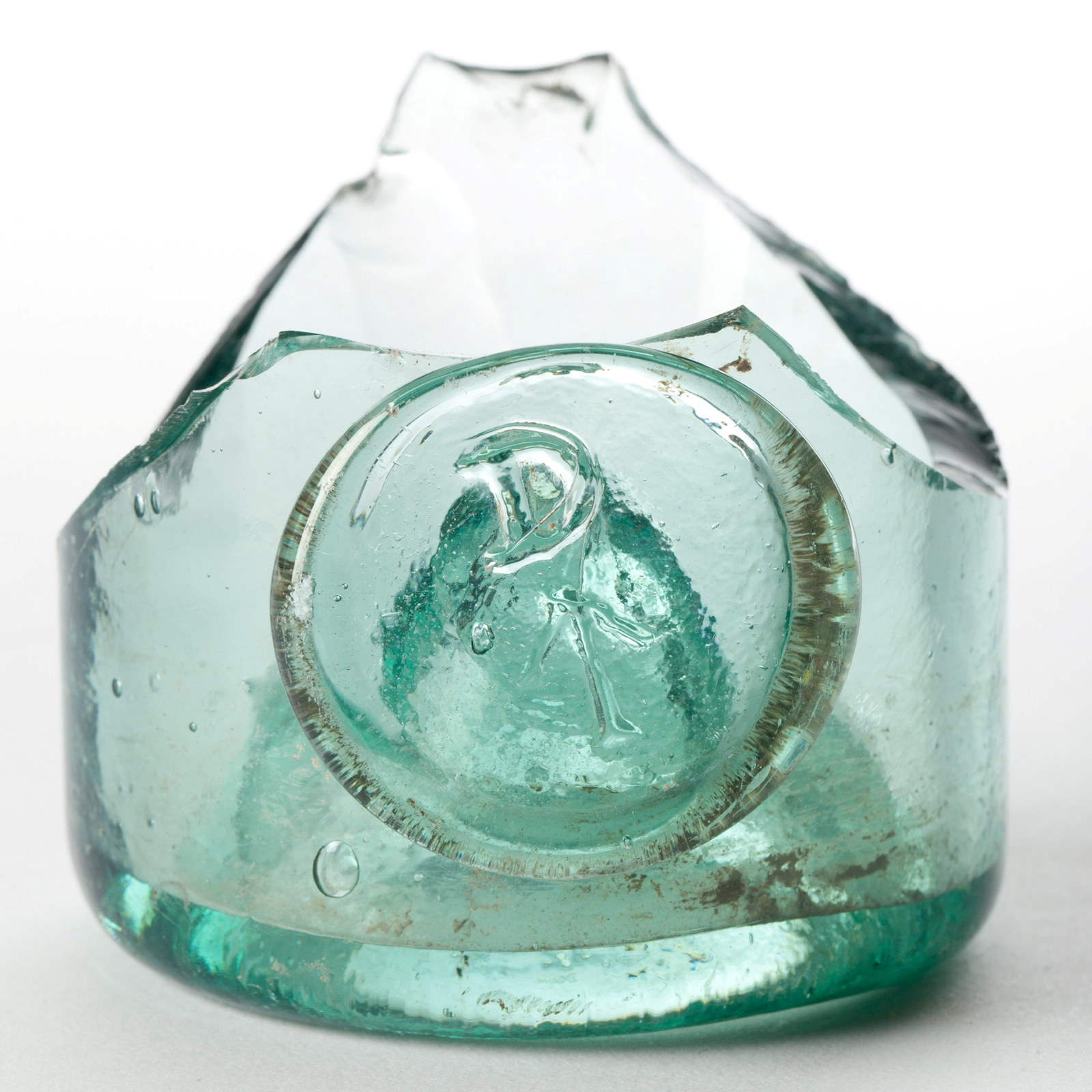 Fragment of heavy bottomed glass bottle with arrow mark.