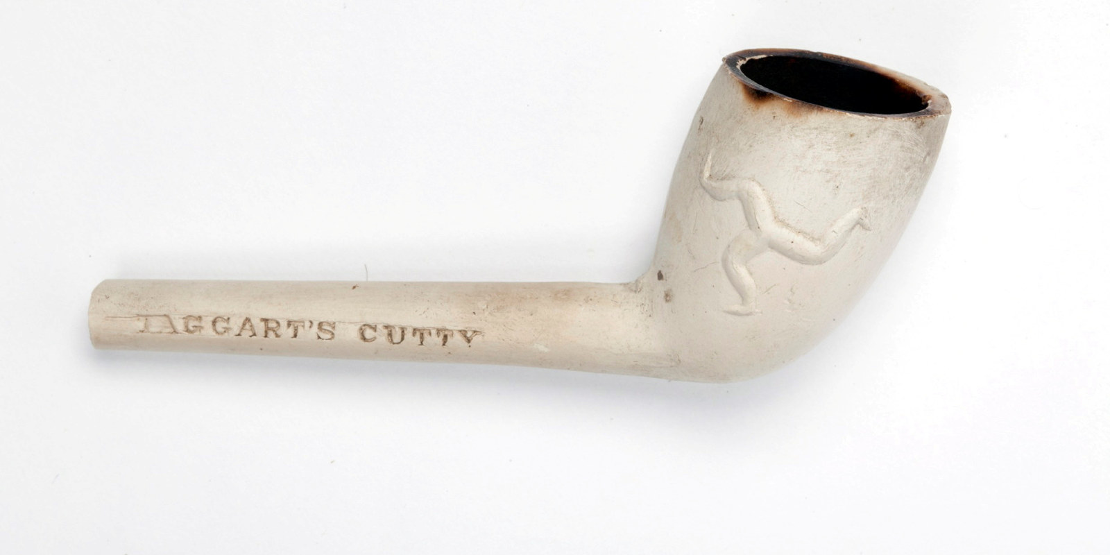 White clay pipe with name carved on stem, bowl with design in relief.