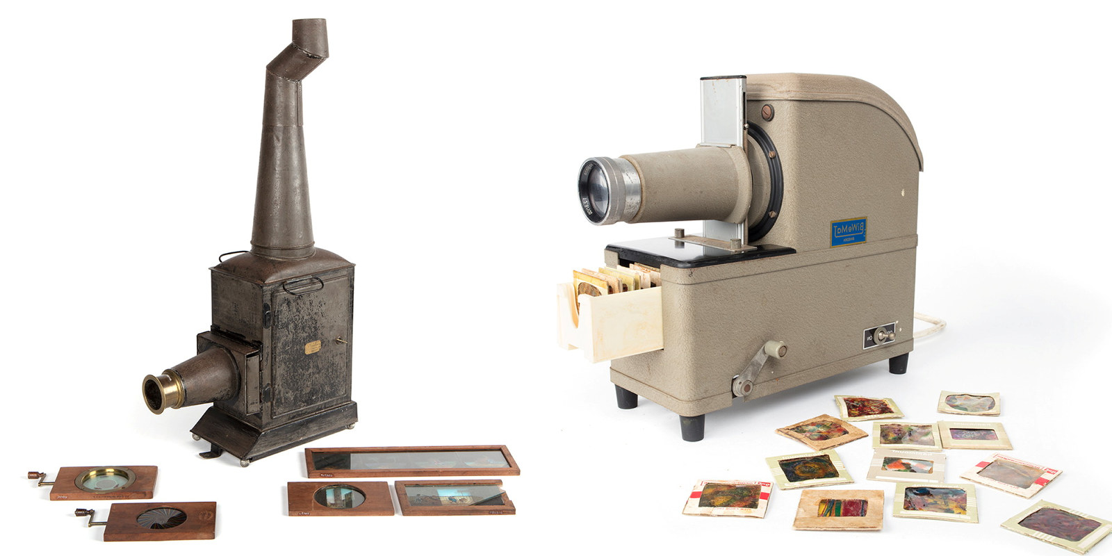 Metal lantern slide projector next to electric projector, both with related slides.