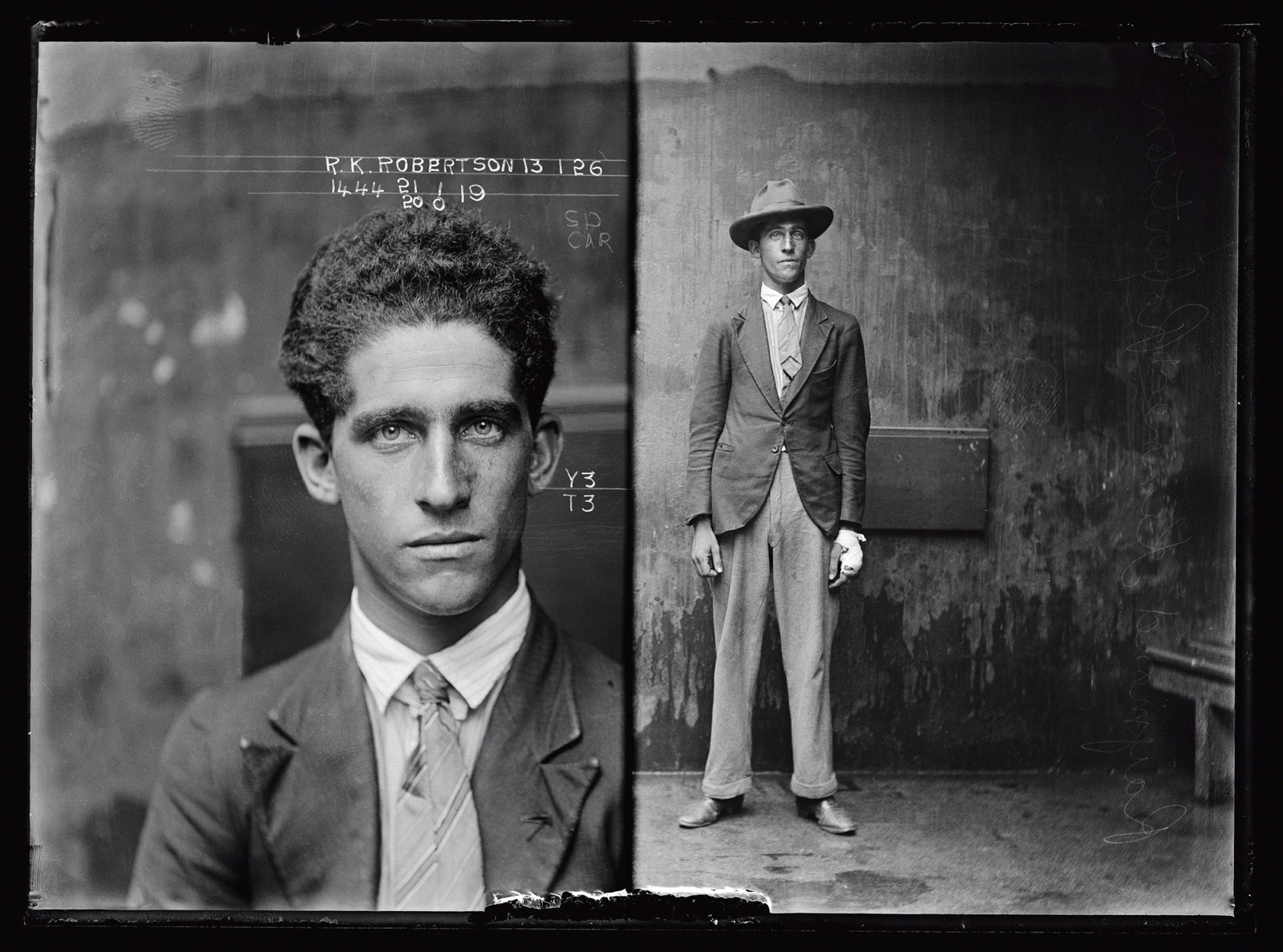 Dual mugshot in black and white; man seated and then man standing, with hat on.