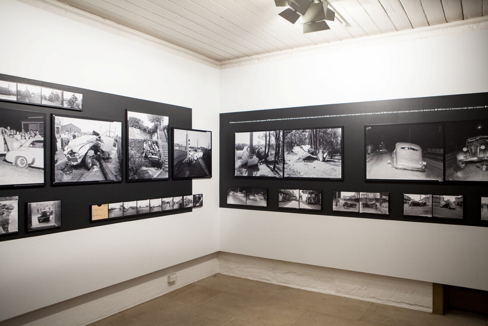 View of gallery space with black and white photographs mounted on white walls.