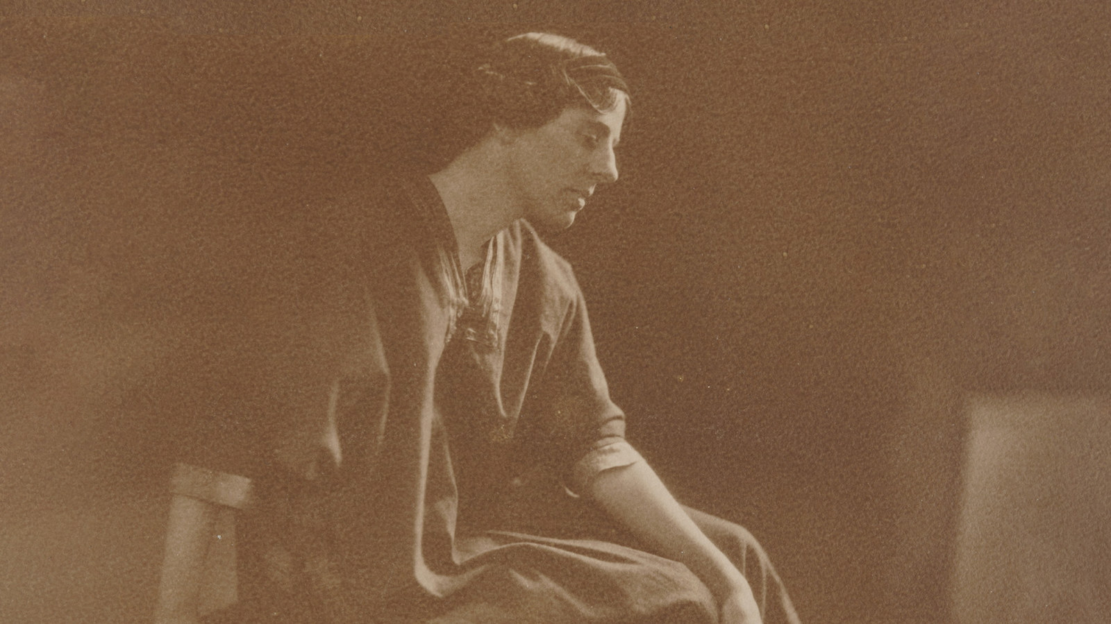 Sepia toned photo of seated woman in profile.