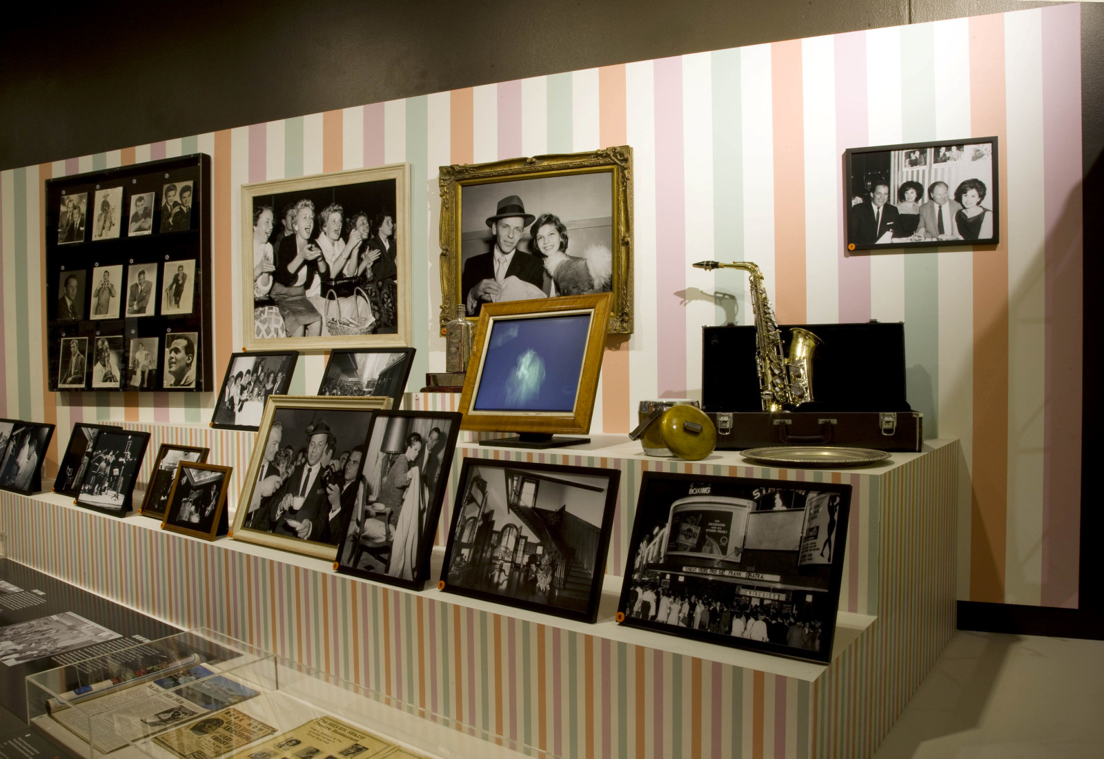 Interior of exhibition with displays cases and framed photographs.