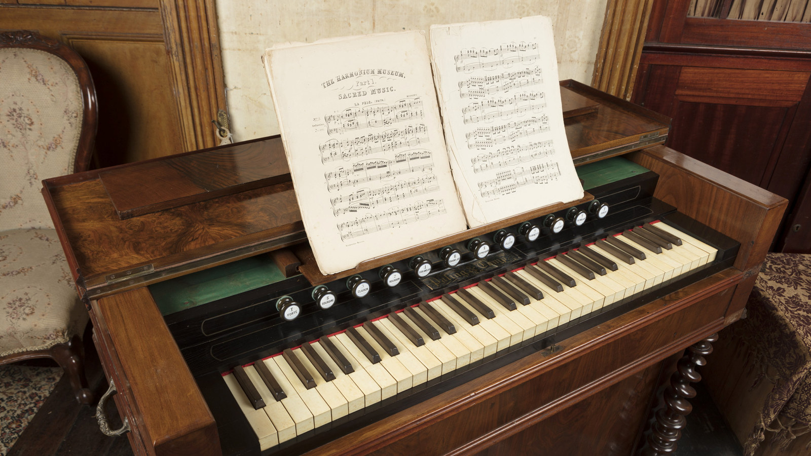 Musical instrument with music book open on stand above keyboard.