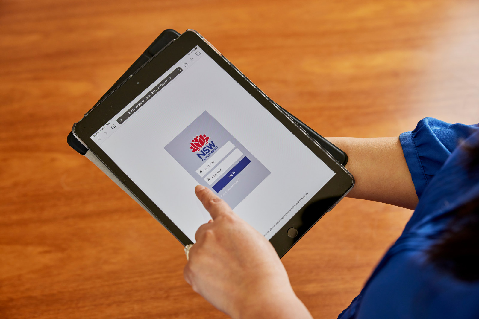 Close up of hand holding an ipad and the homepage for the State Records website