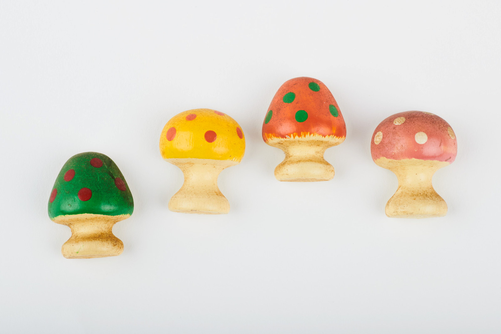 Small mushroom magnets in varied colours with spots.