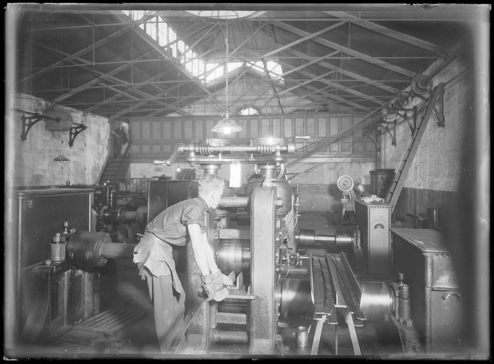 Black and white photo of a man working a coin press
